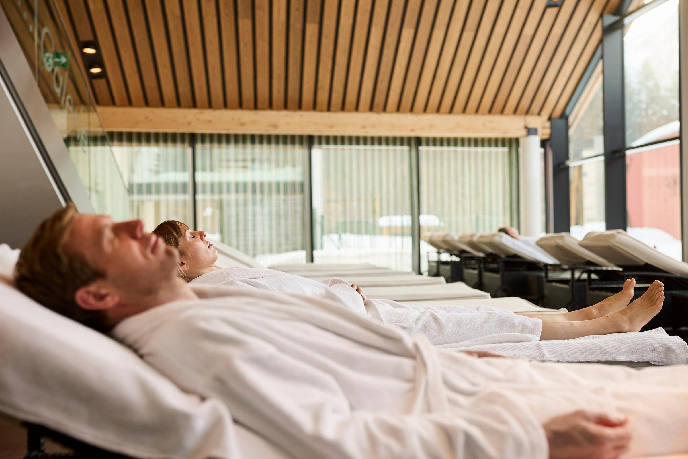 Entspannter Gast liegt im Premium Cluburlaub bei Aldiana auf dem Bett in einer eleganten Lounge