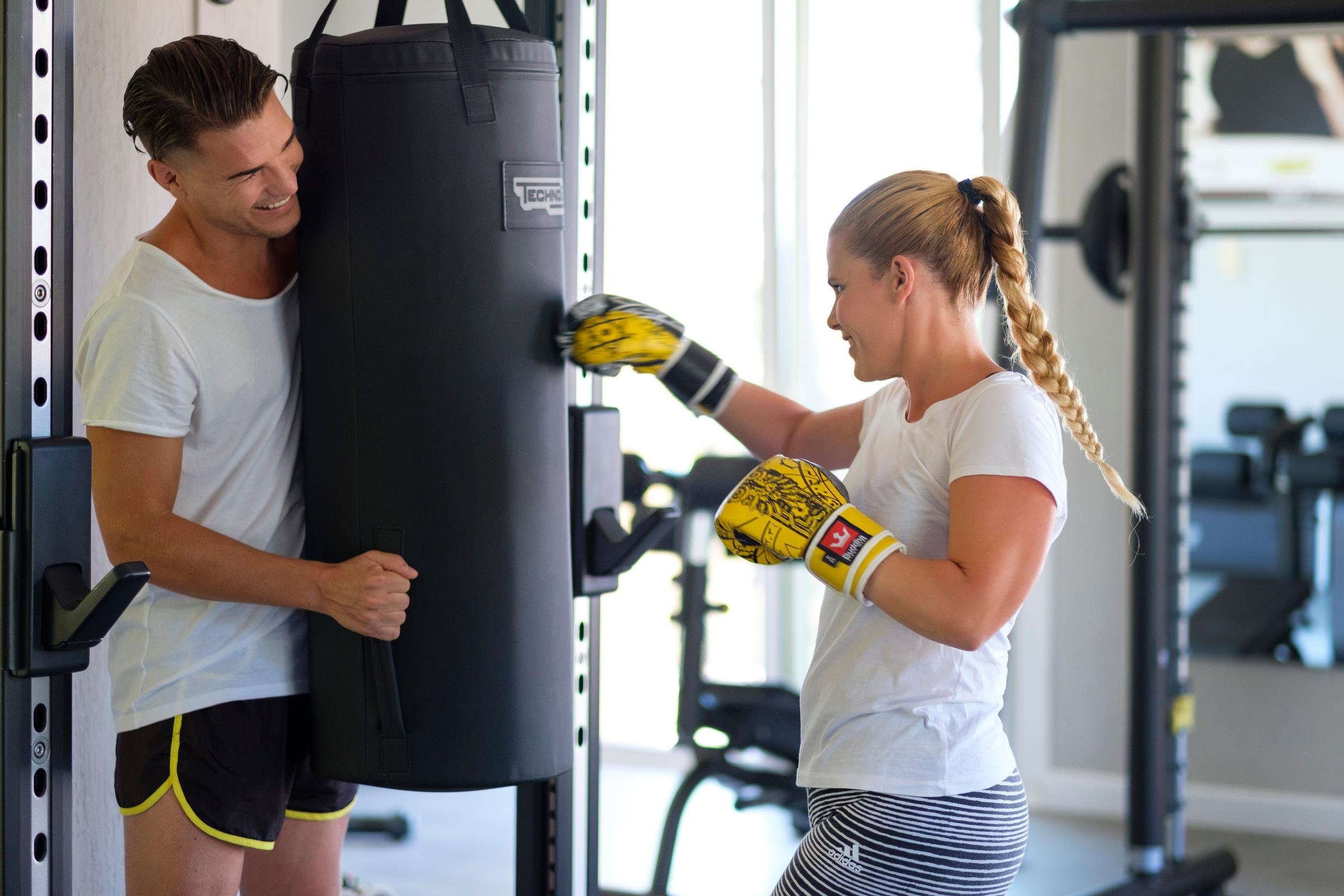 Zwei junge Mädchen trainieren im Fitnessstudio mit Boxsack, fördern Gesundheit und Fitness