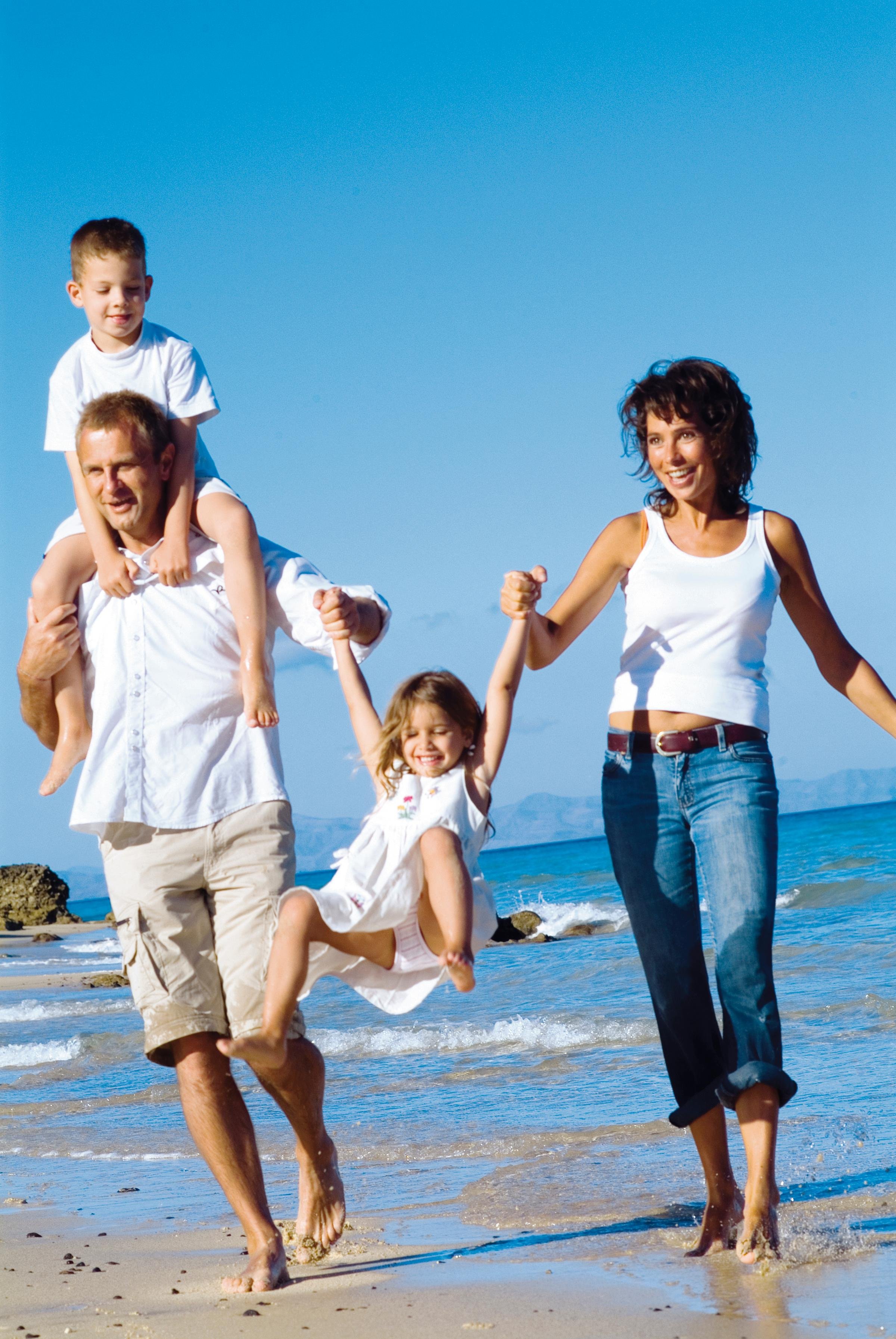 Familie beim Spielen am Strand im sonnigen Urlaub bei Aldiana an der Küste