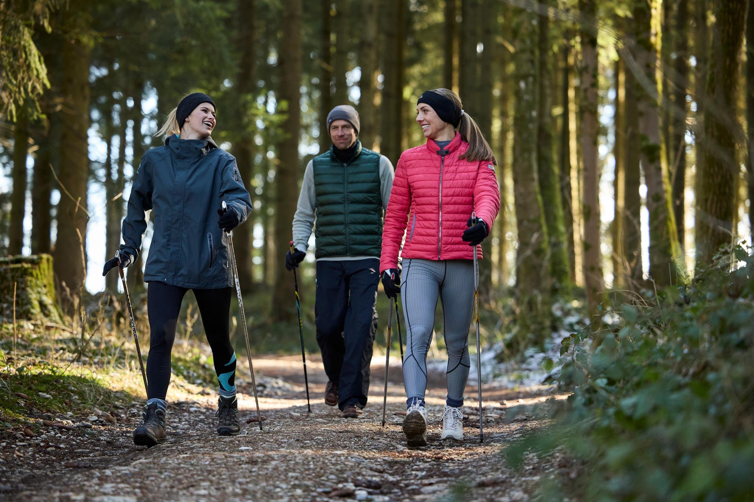 Drei Personen wandern im Wald, genießen einen Premium Cluburlaub im Grünen