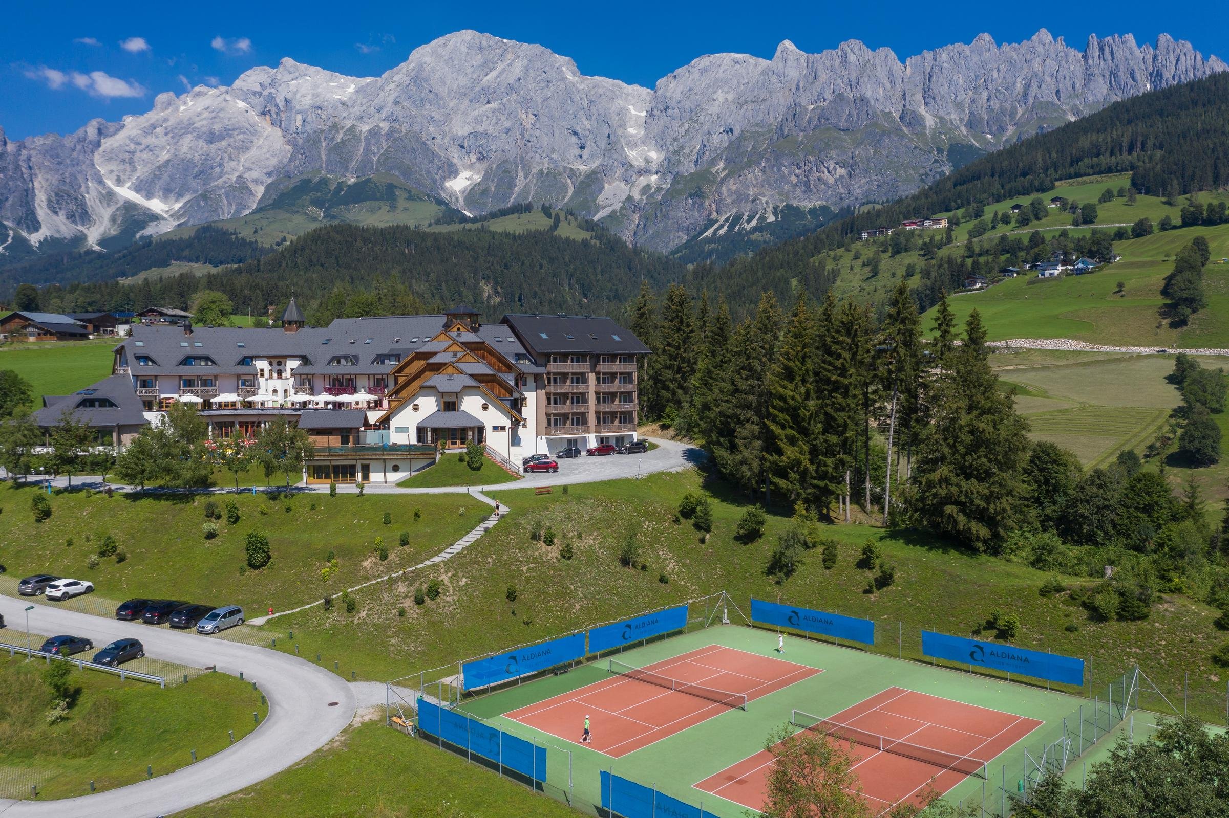 Aldiana Premium Cluburlaub mit Blick auf Berge, Hotel und Tennisplätze in grüner Landschaft