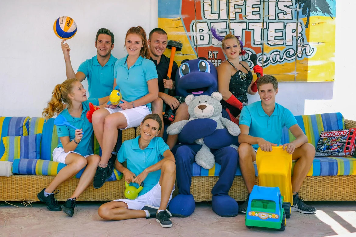 Familie beim Spielen im Indoor-Spielbereich, sitzend auf einer Couch, mit bunten Spielsachen