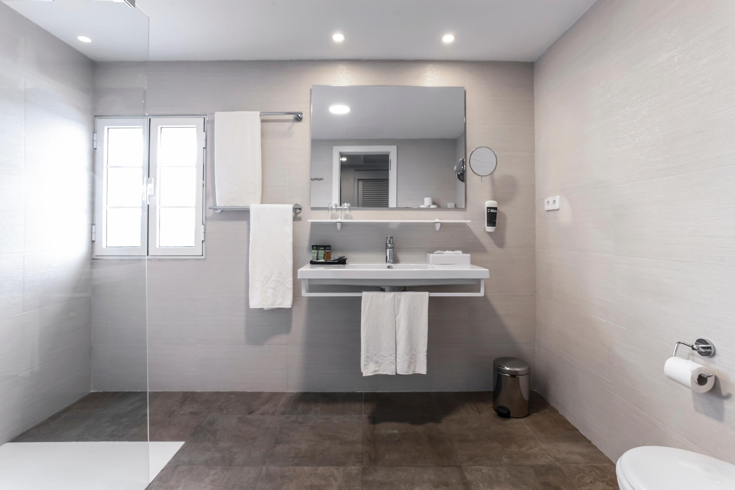 Ein stilvolles Badezimmer im Premium Cluburlaub bei Aldiana, mit Waschbecken, Spiegel und Toilette