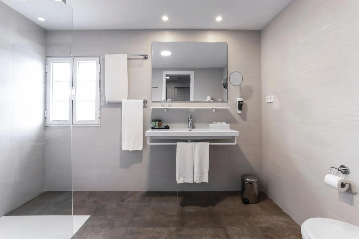 Ein stilvolles Badezimmer im Premium Cluburlaub bei Aldiana, mit Waschbecken, Spiegel und Toilette