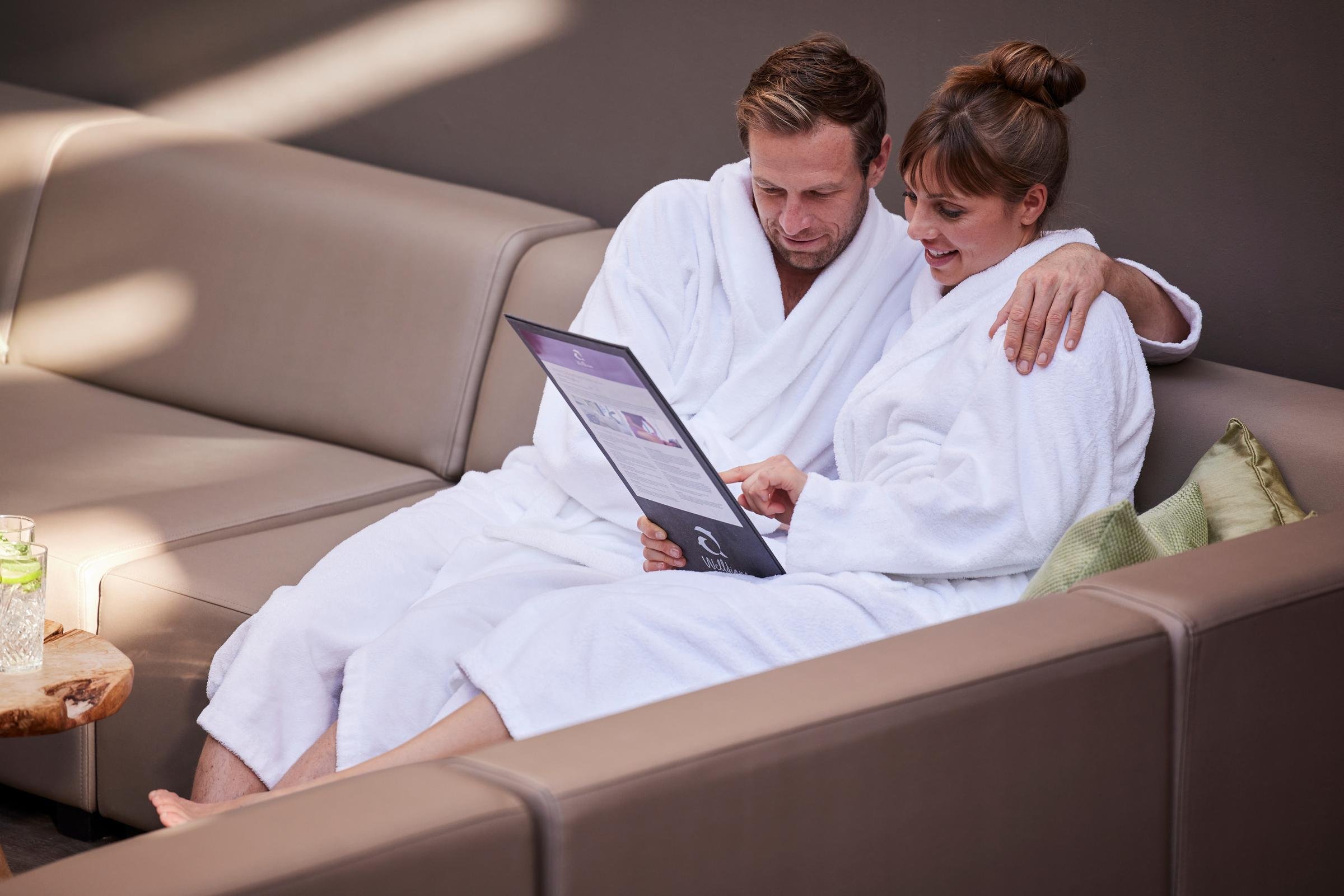 Zwei Personen in Bademänteln auf Sofaecke im Spa Bereich bei Aldiana, entspannte Atmosphäre