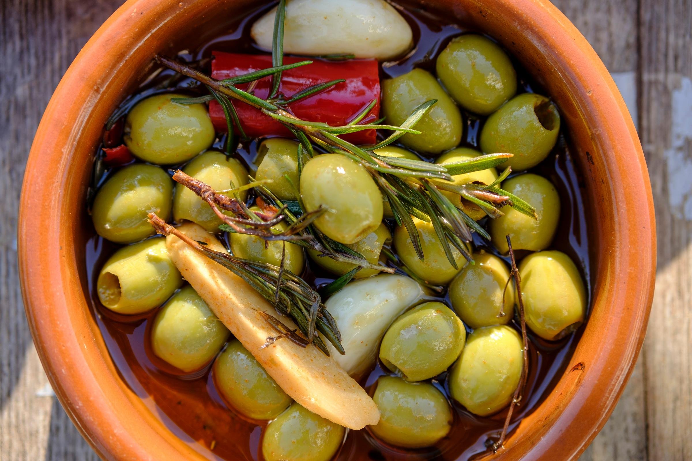 Buntes Oliven- und Kräutergemedley in einem Keramikschüssel für Premium Cluburlaub