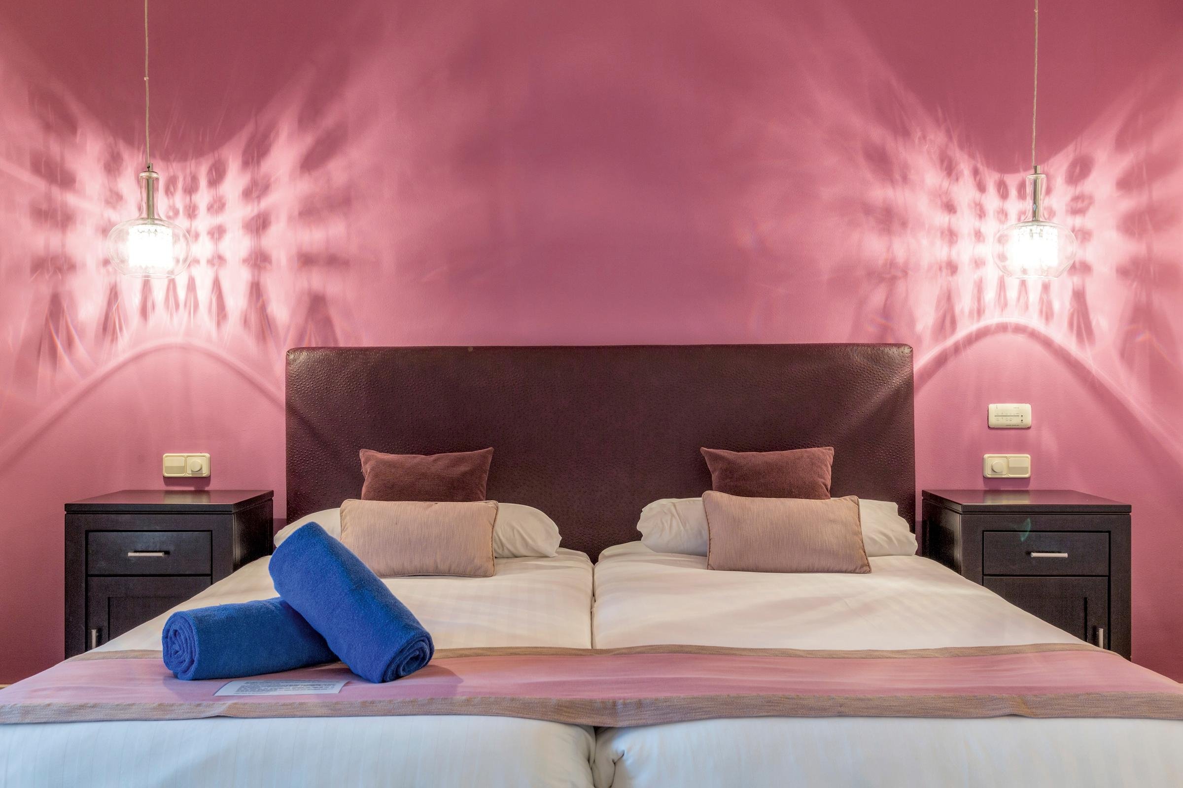Doppelzimmer im Premium Cluburlaub bei Aldiana mit pinker Wand und gemütlicher Einrichtung