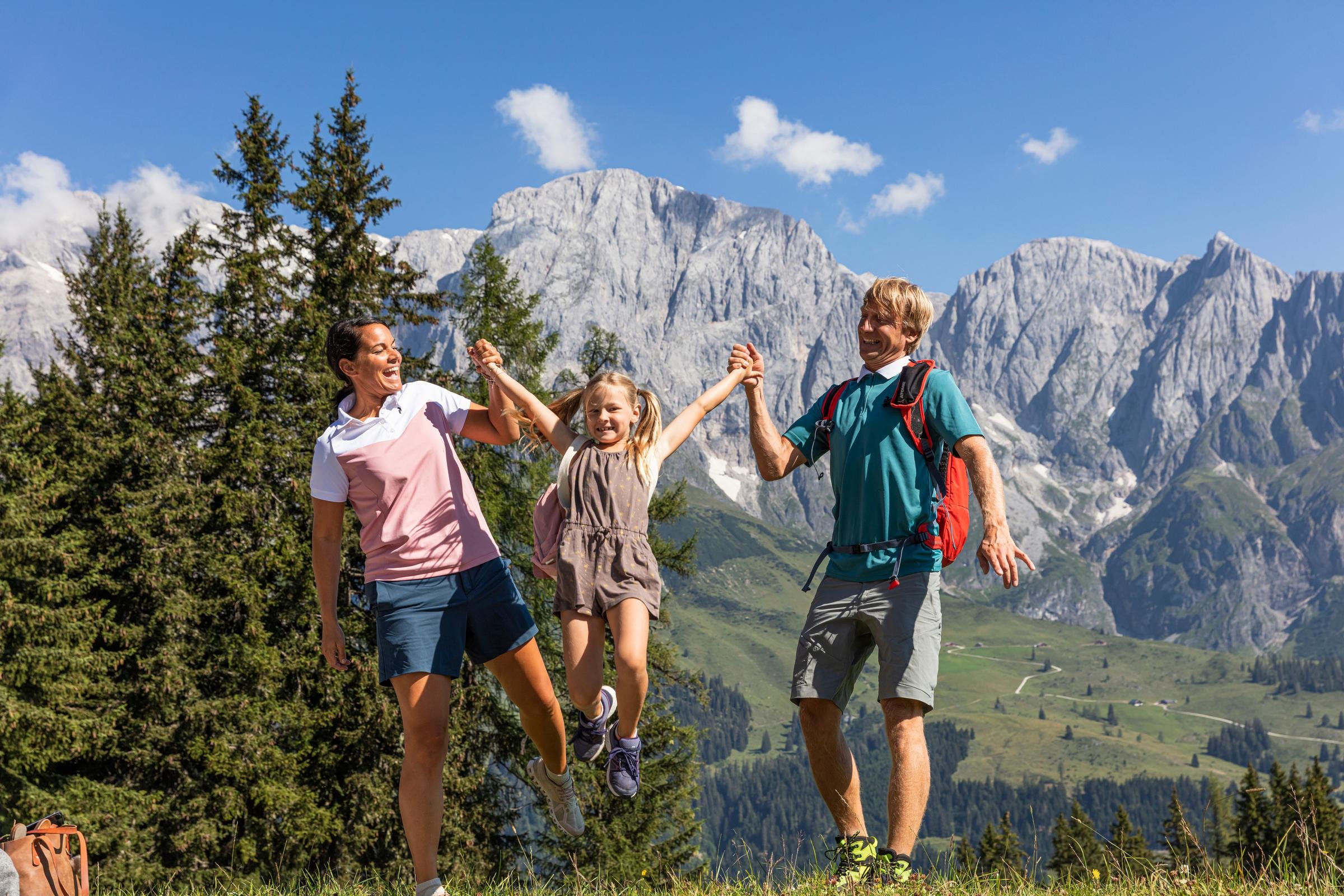 Zwei Kinder und ein Erwachsener beim Wandern in den Bergen, Natur, Spaß, Outdoor-Aktivität
