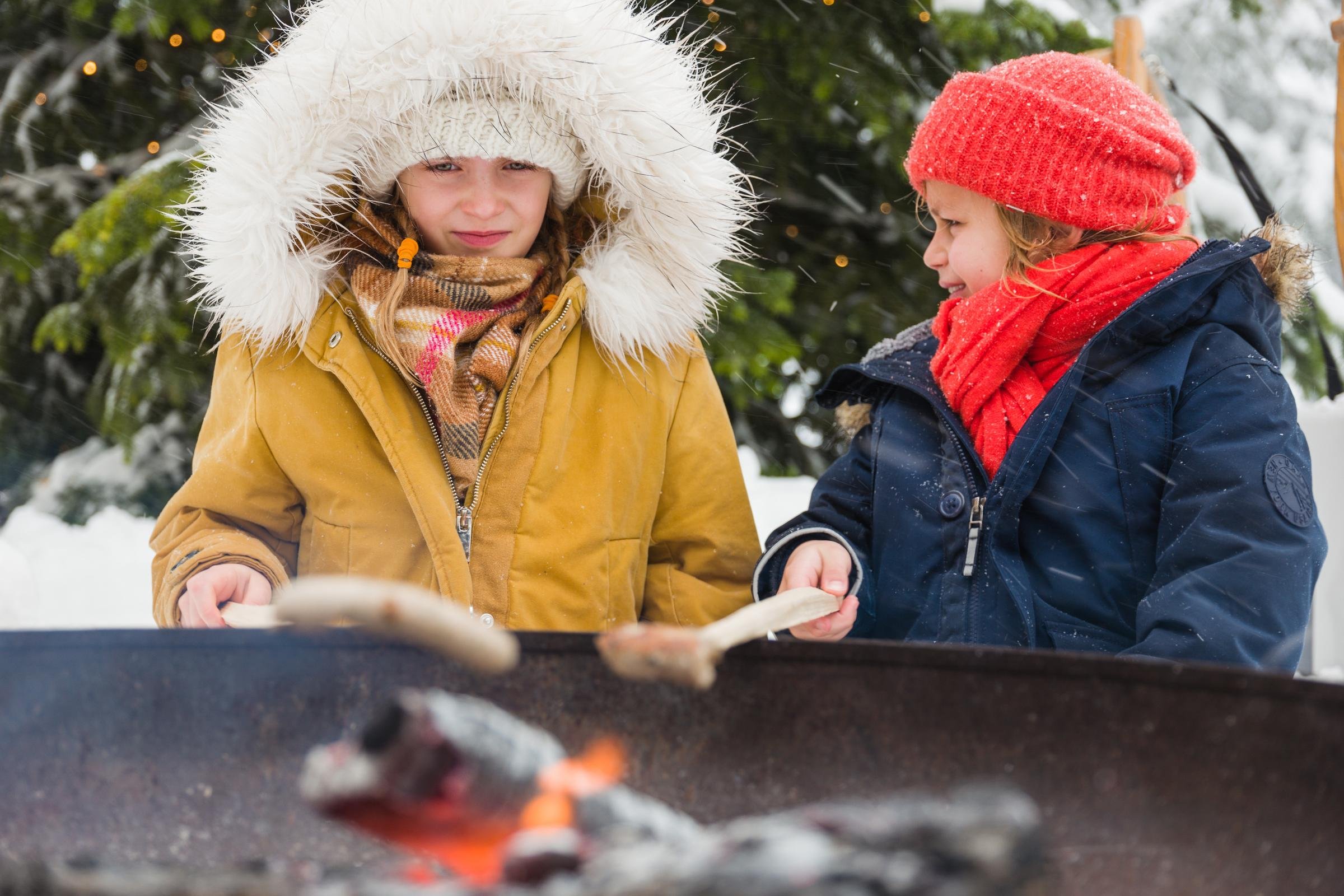 Zwei Kinder beim Grillen im Winter, outdoor, in warmer Kleidung, bei Schnee, im Aldiana Club