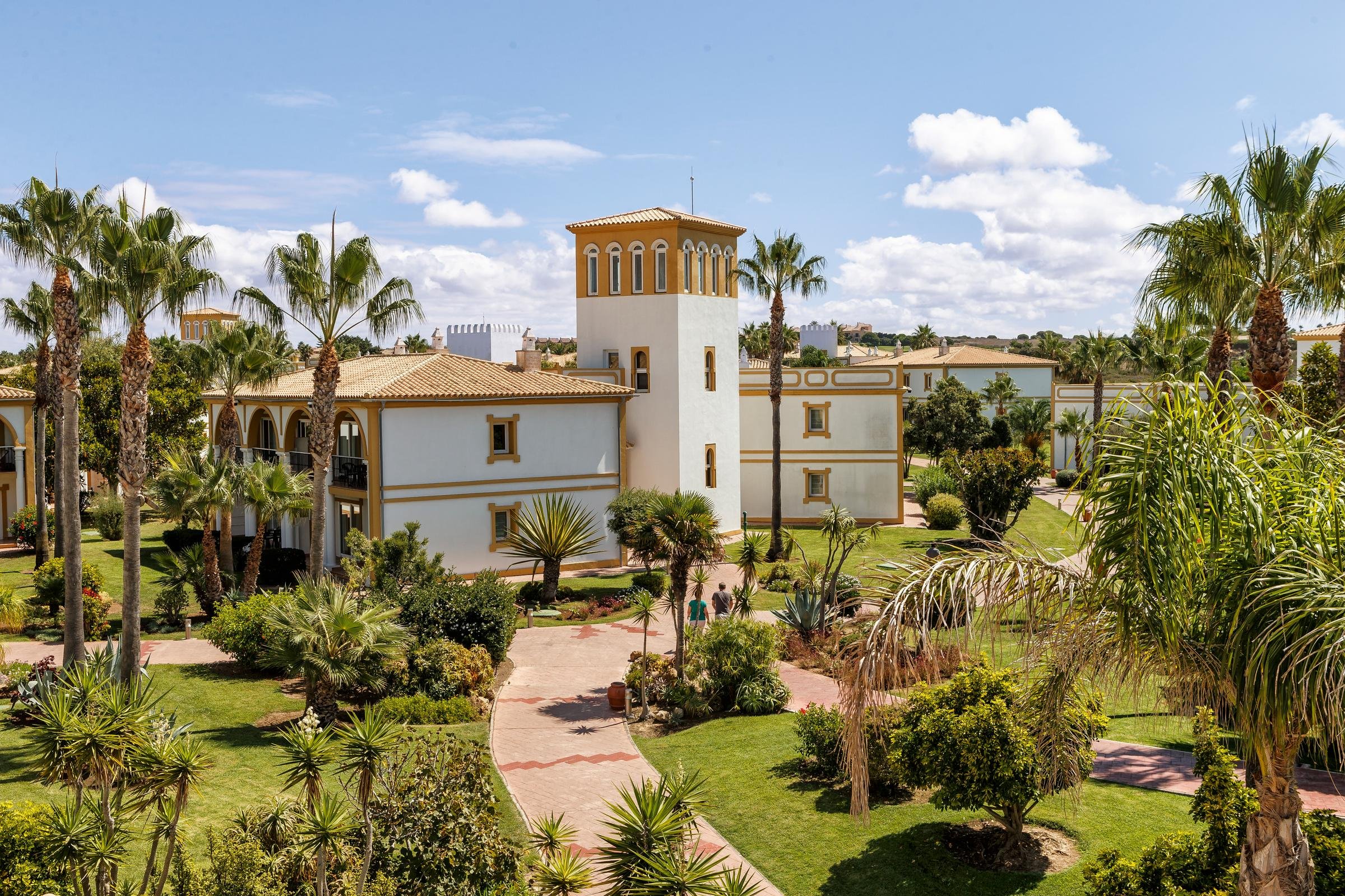 Moderne Hotelanlage mit mediterranem Stil, tropischer Vegetation und Urlaubsatmosphäre