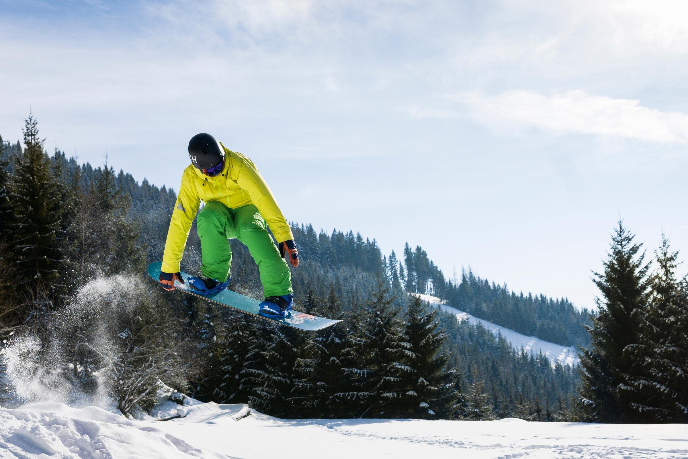 Skifahrer springt über Schnee in einer verschneiten Waldlandschaft, Sport und Natur erleben