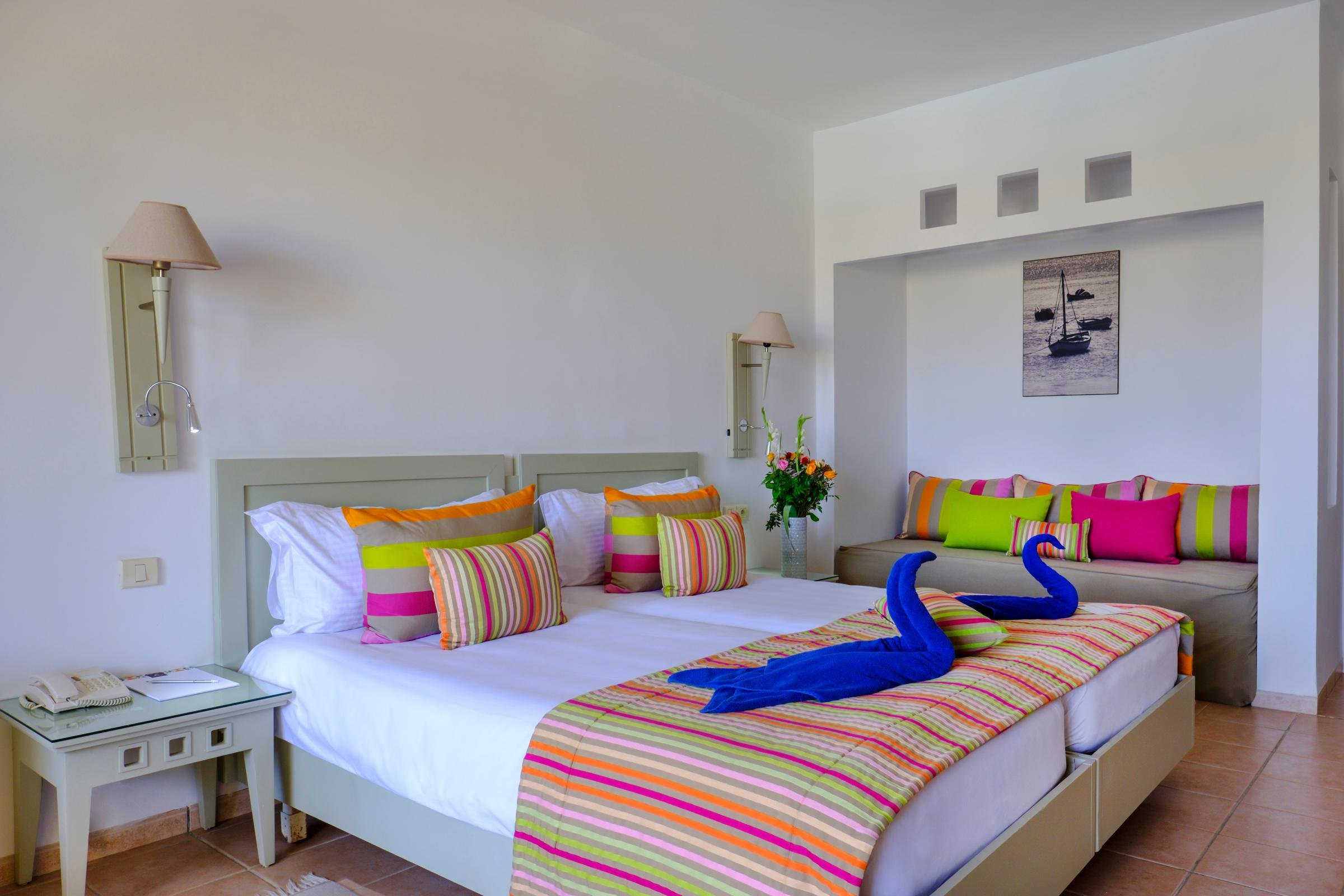 Doppelzimmer im Aldiana Club mit bunten Bettdecken und Schwanenhandtüchern auf dem Bett