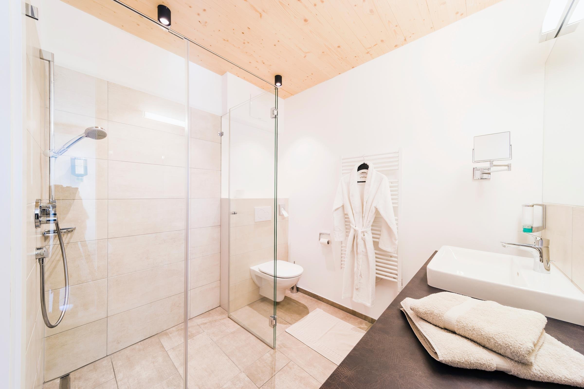 Modern Badezimmer mit Dusche, WC, Waschbecken und Handtüchern im Premium Cluburlaub