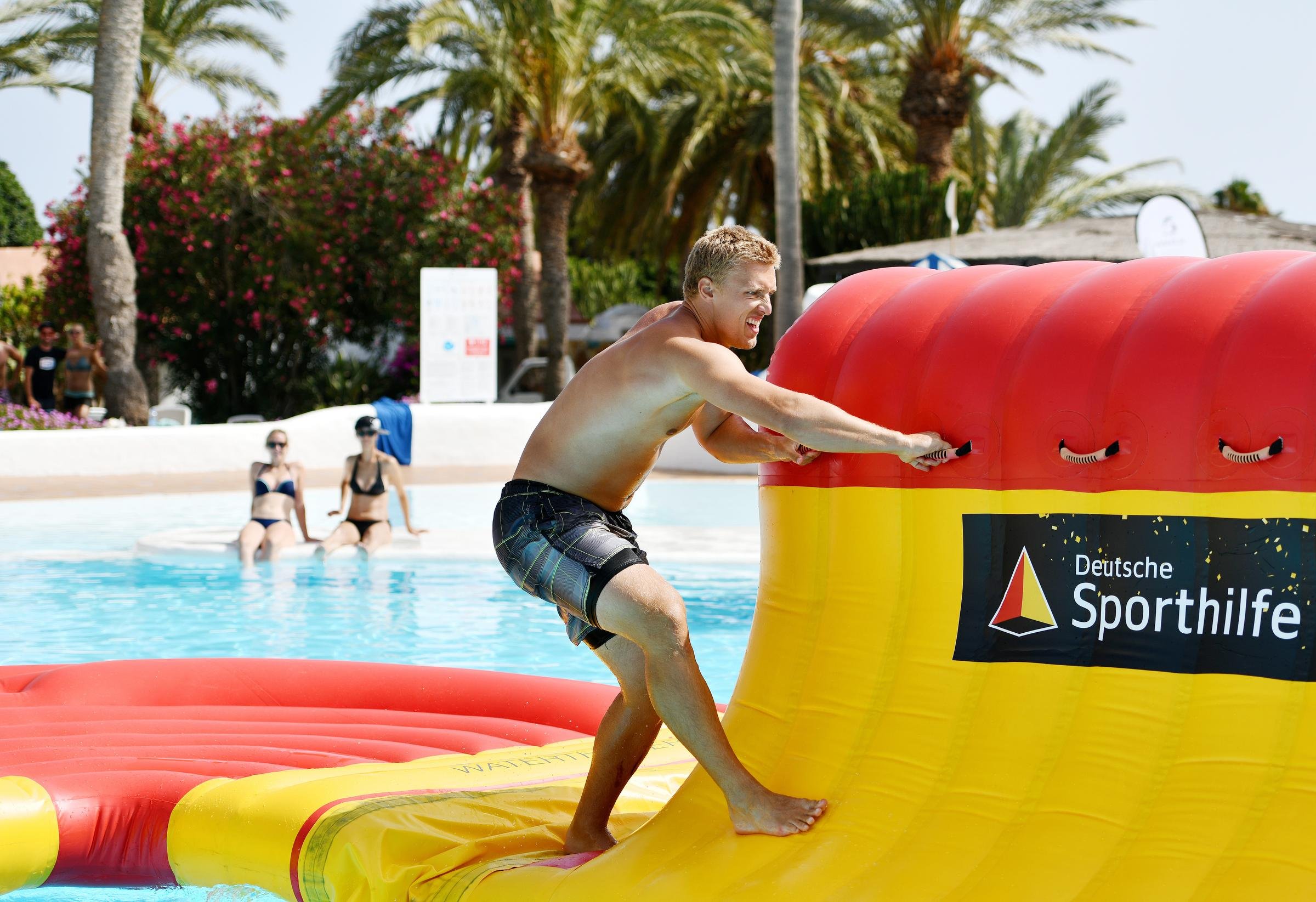 Junge schwimmt auf Wasserpark-Inflatable bei Aldiana im Premium Cluburlaub