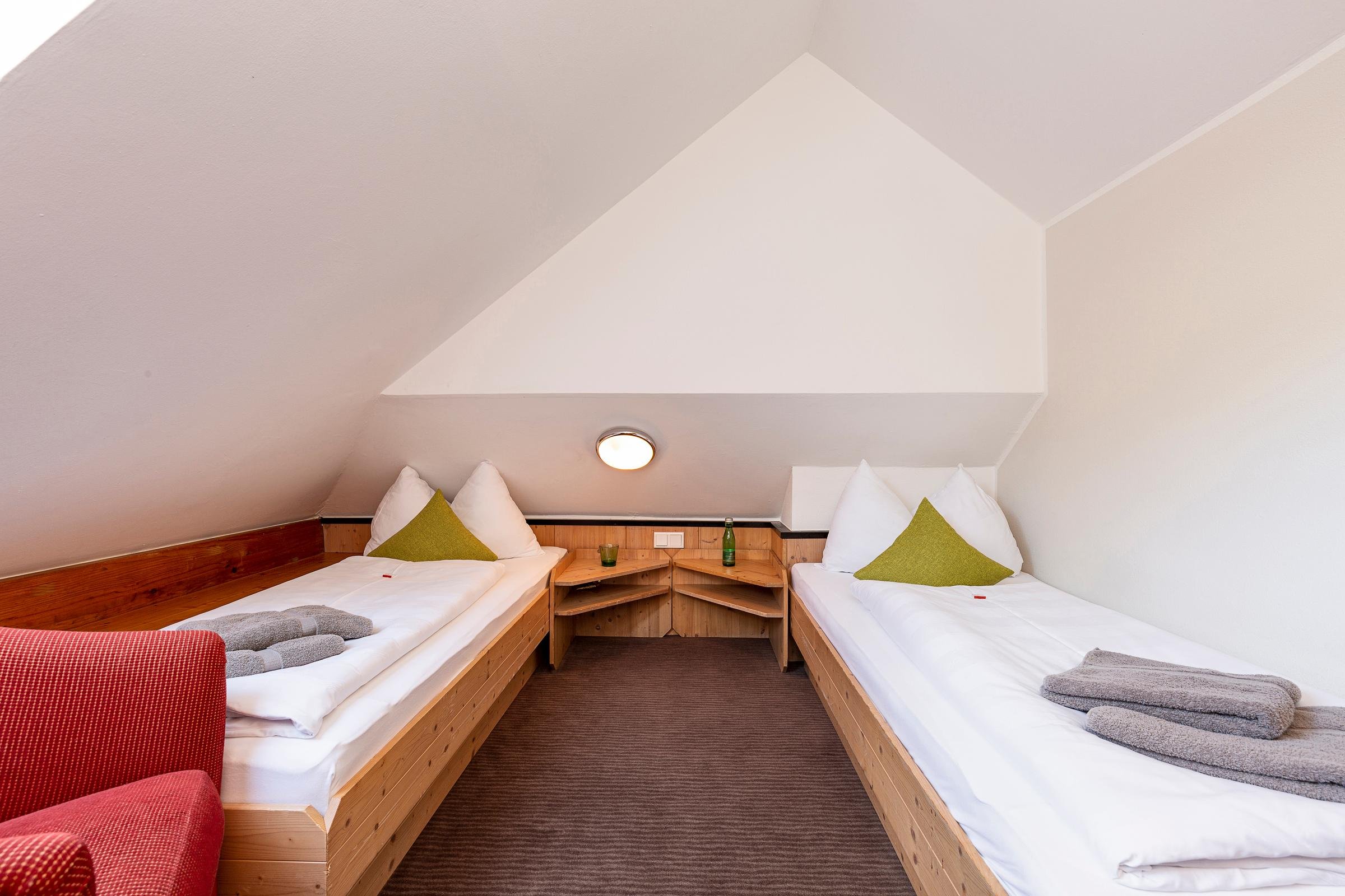 Zwei Gästezimmer bei Aldiana mit Einzelbetten, grünen Kissen und bequemen Bettwäsche