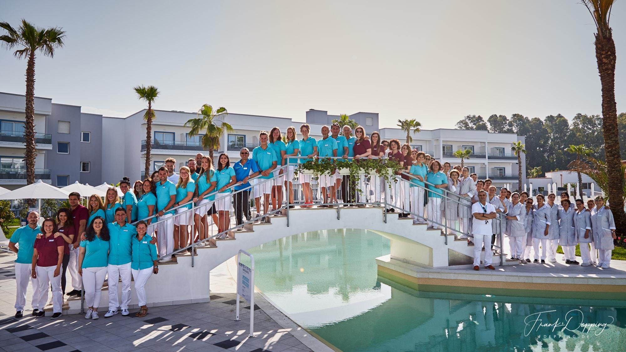 Gruppe im weißen und blauen Uniformen an einem Pool bei Aldiana Premium Cluburlaub