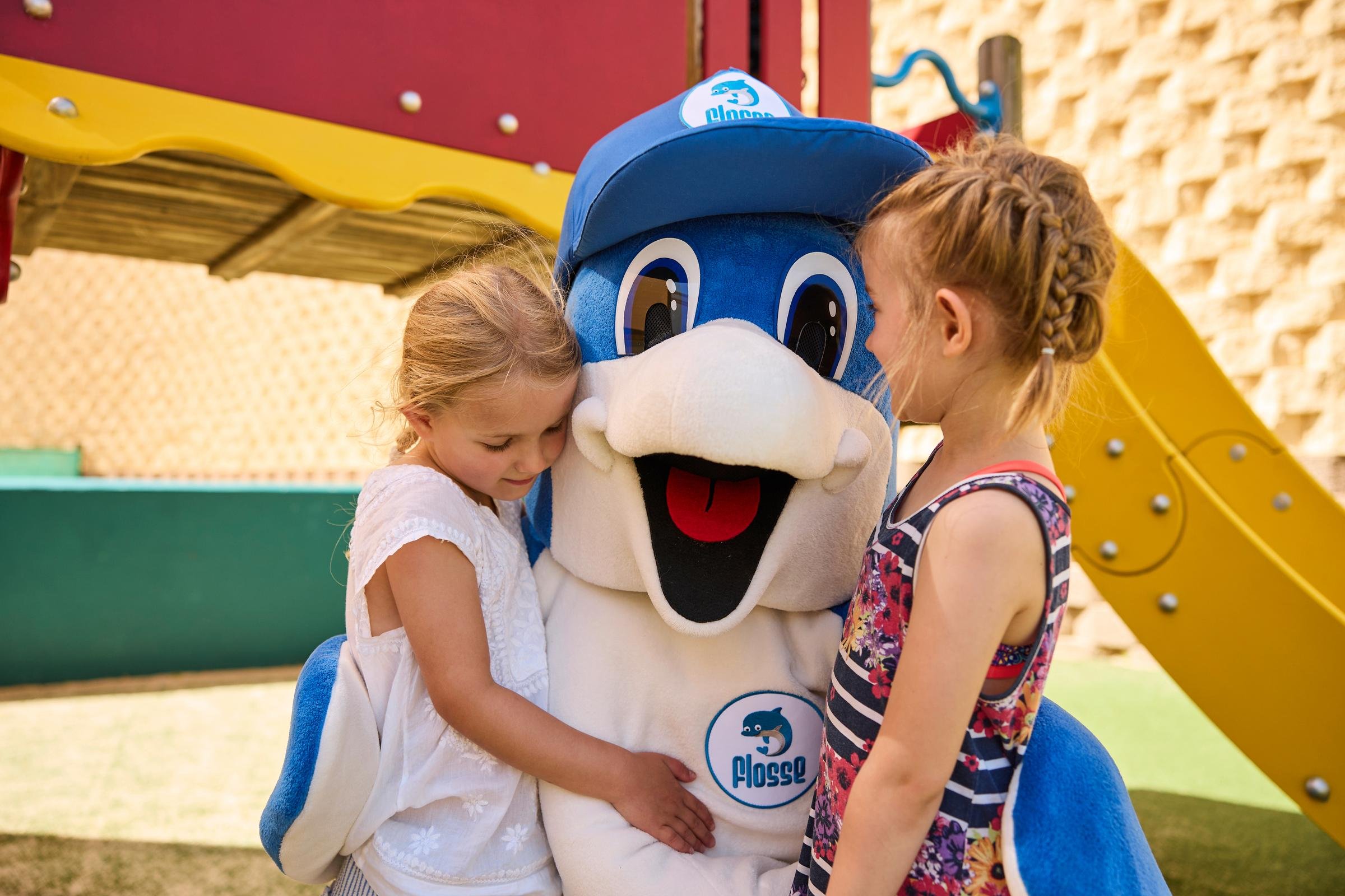 Kinder umarmen den freundlichen Clownfigur bei Aldiana im Premium Cluburlaub