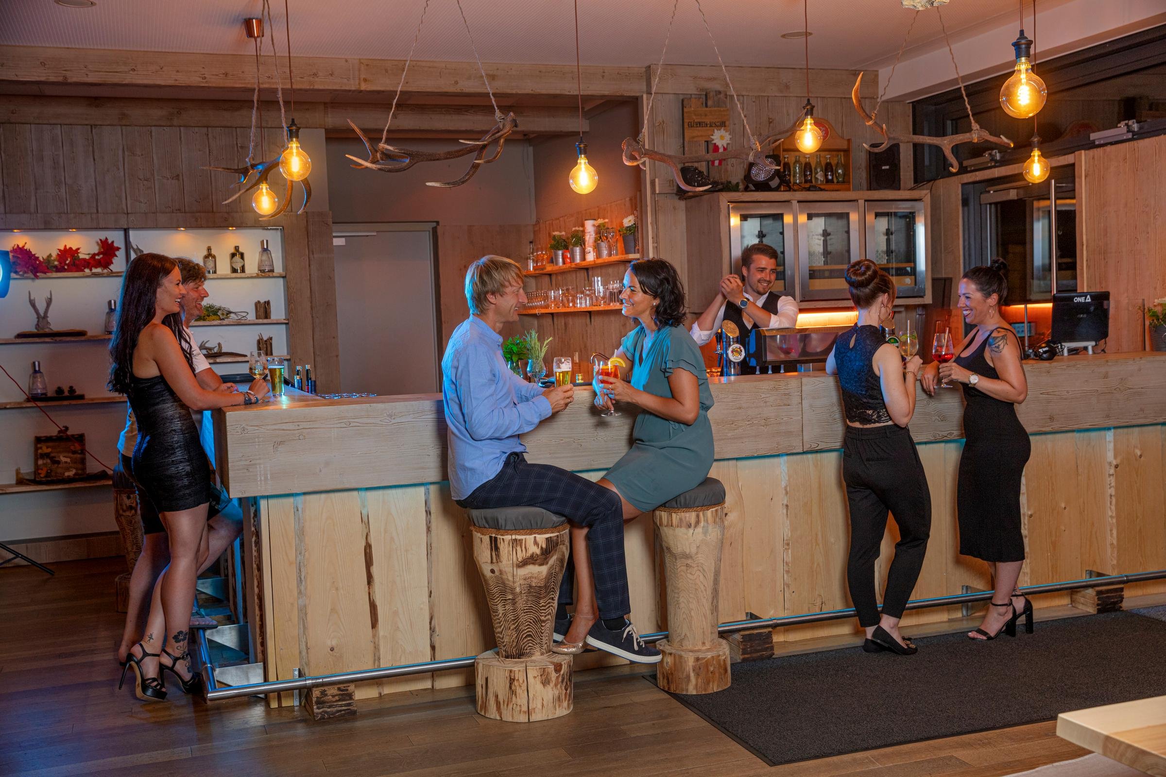 Leute nehmen Drinks im gemütlichen Stüberl