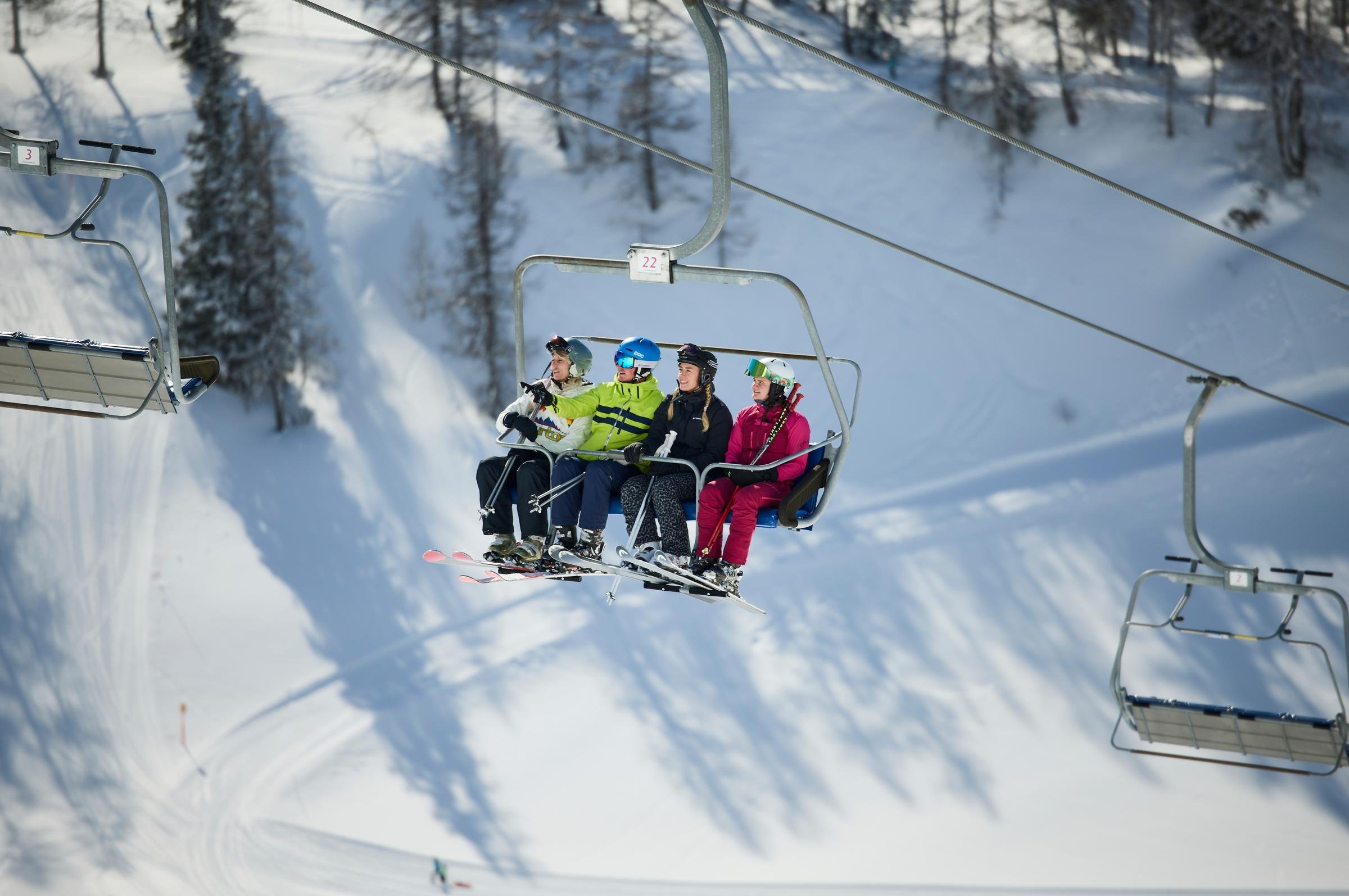 Skifahrer auf der Aldiana Piste beim Premium Cluburlaub im Schnee, Bergkulisse, Winterfreude.