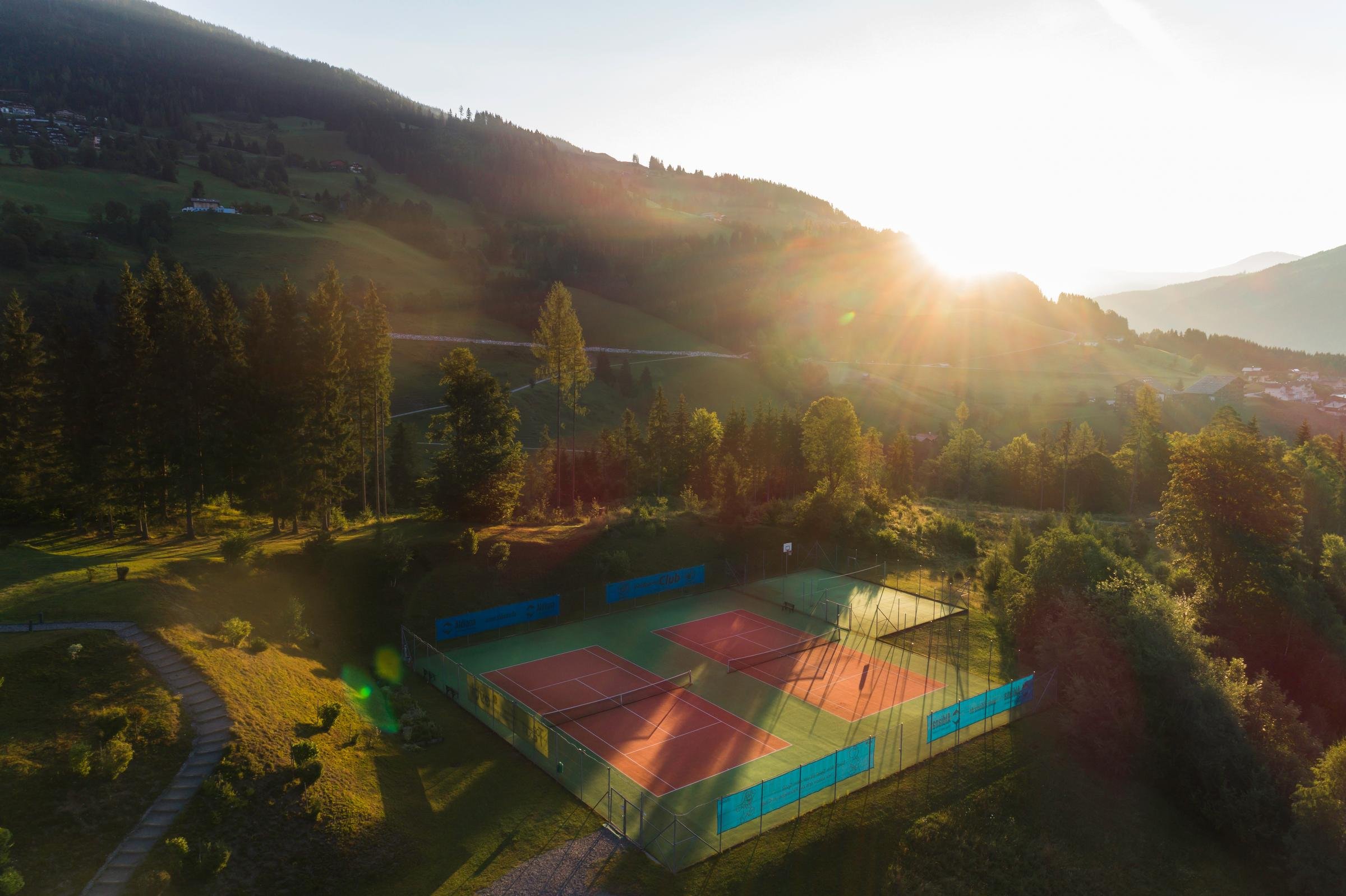 Tennisplatz mit Bergblick und Sonnenaufgang 