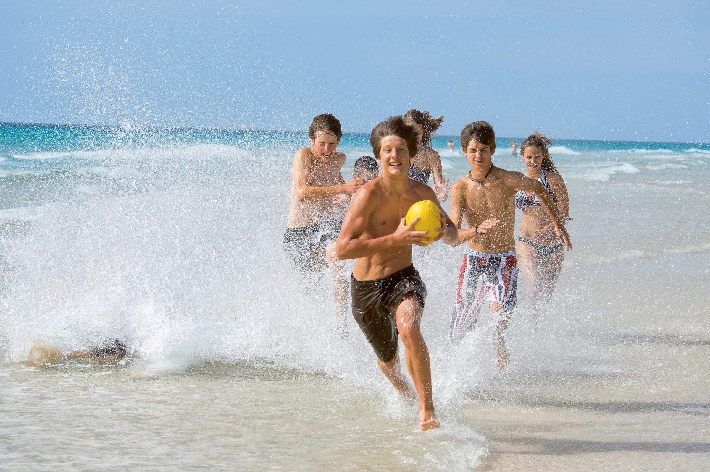 Bunt spielende Kinder im Wasser am Strand bei Aldiana, Premium Cluburlaub.