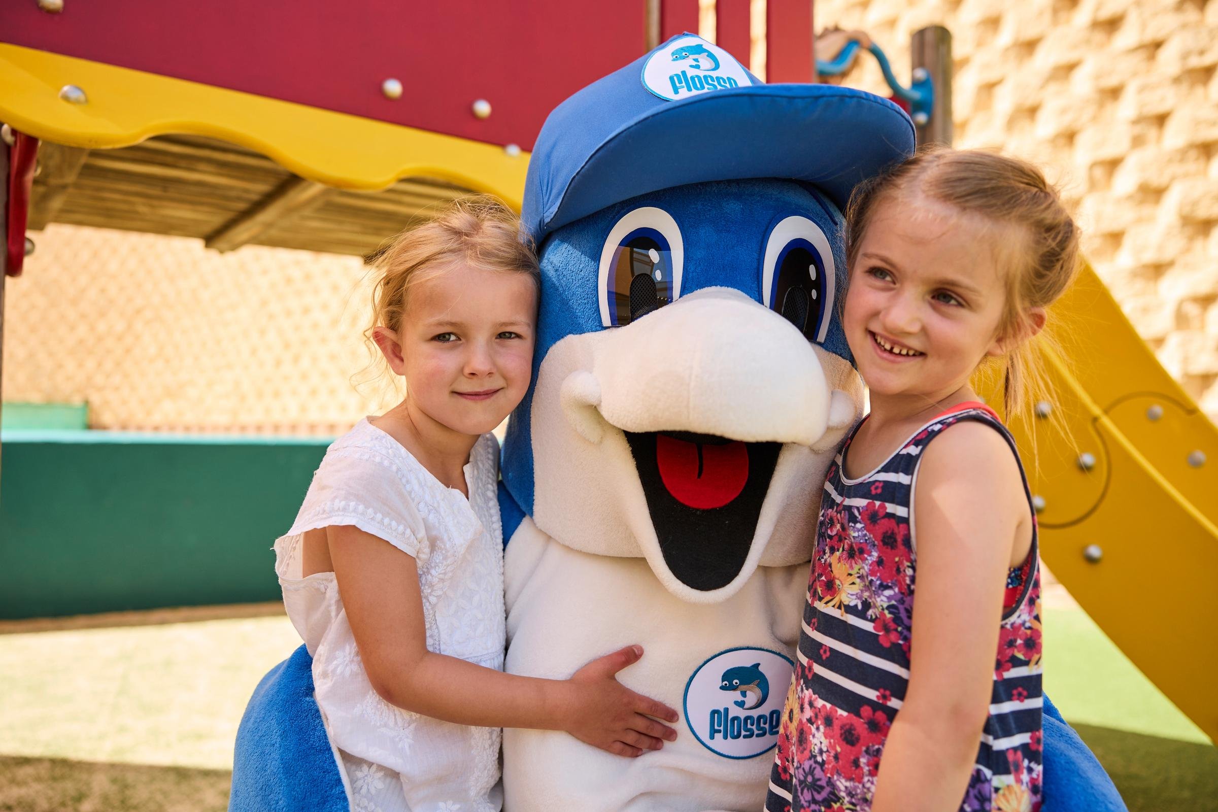 Zwei Kinder mit einem mascotte im Premium Cluburlaub bei Aldiana on a Spielplatz