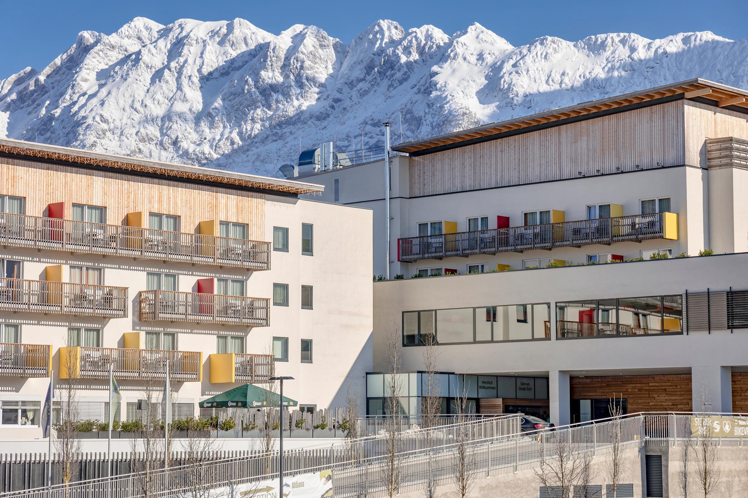 Moderne Hotelanlage von Aldiana mit Balkon und Blick auf die verschneiten Berge