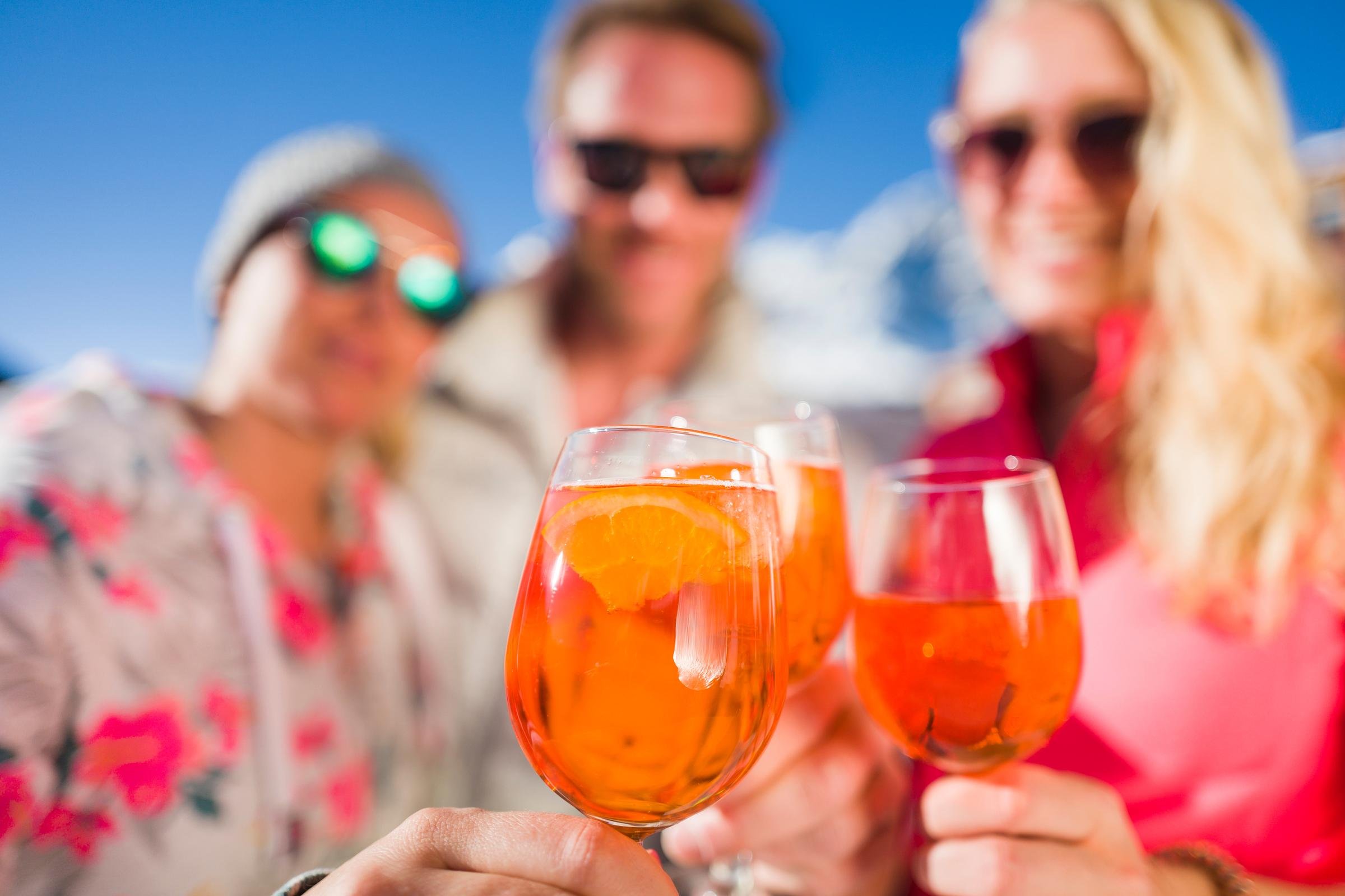 Drei Personen beim Sonnenuntergang mit alkoholischen Getränken in einem Premium Cluburlaub