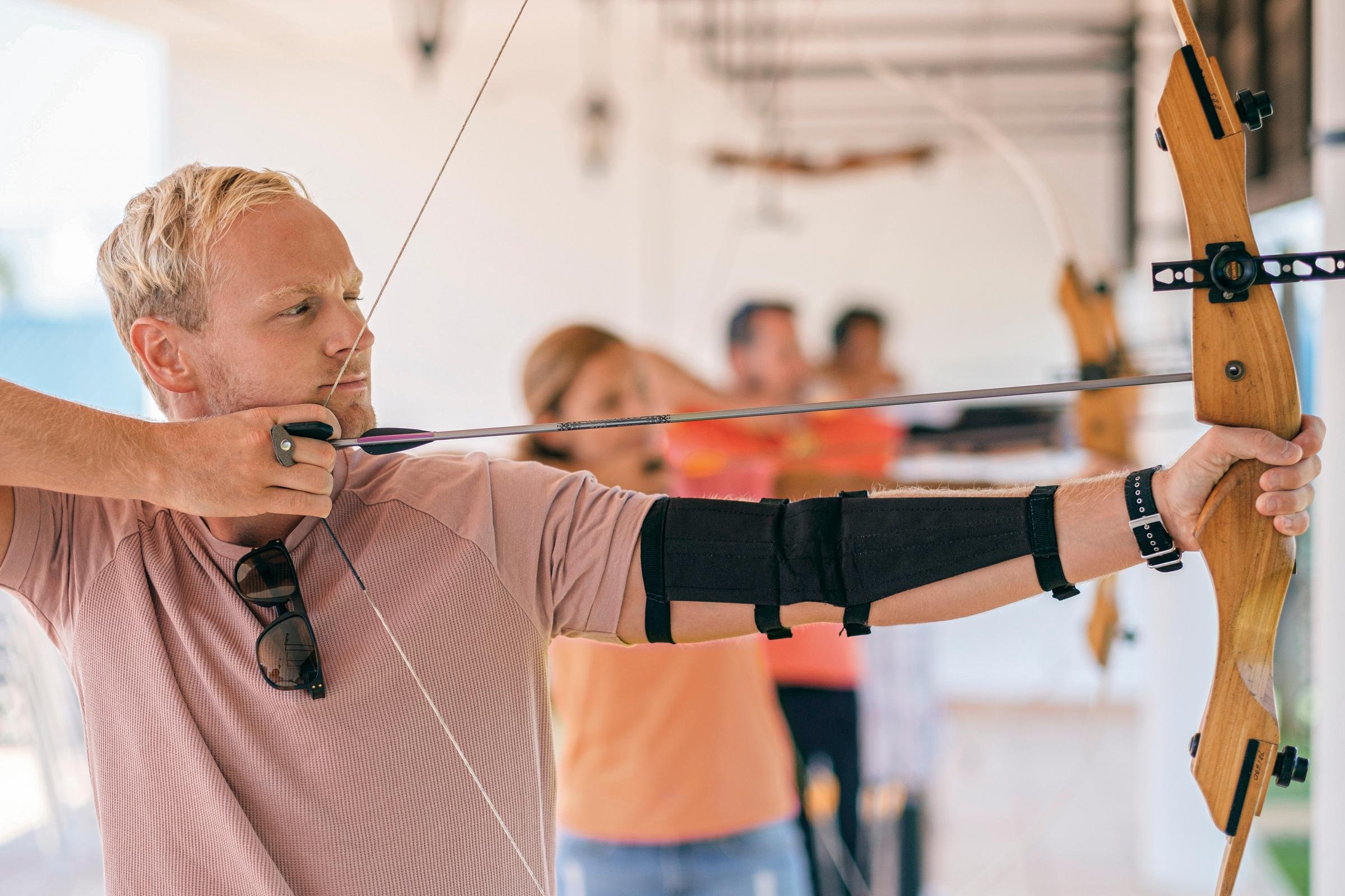 Mann beim Bogenschießen für einen Premium Aldiana Cluburlaub, Fokus auf Sport und Freizeit