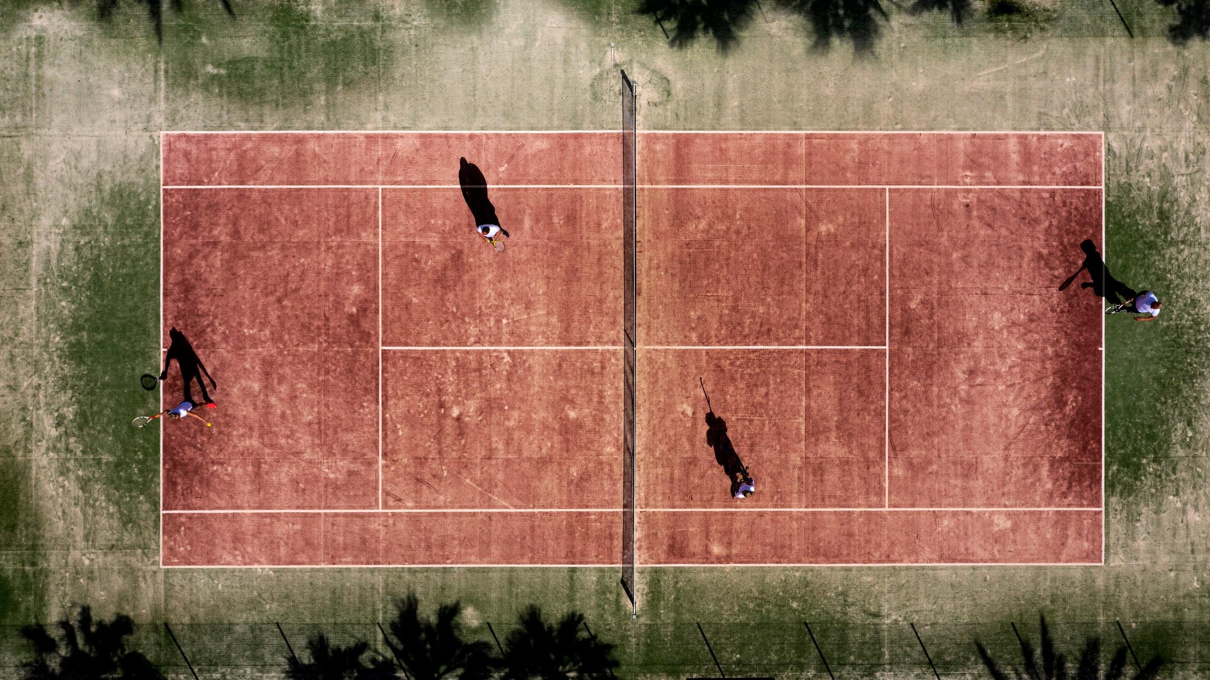Aufnahme eines Tennisplatzes mit Spielern, Blick von oben, ideal für Premium Cluburlaub.