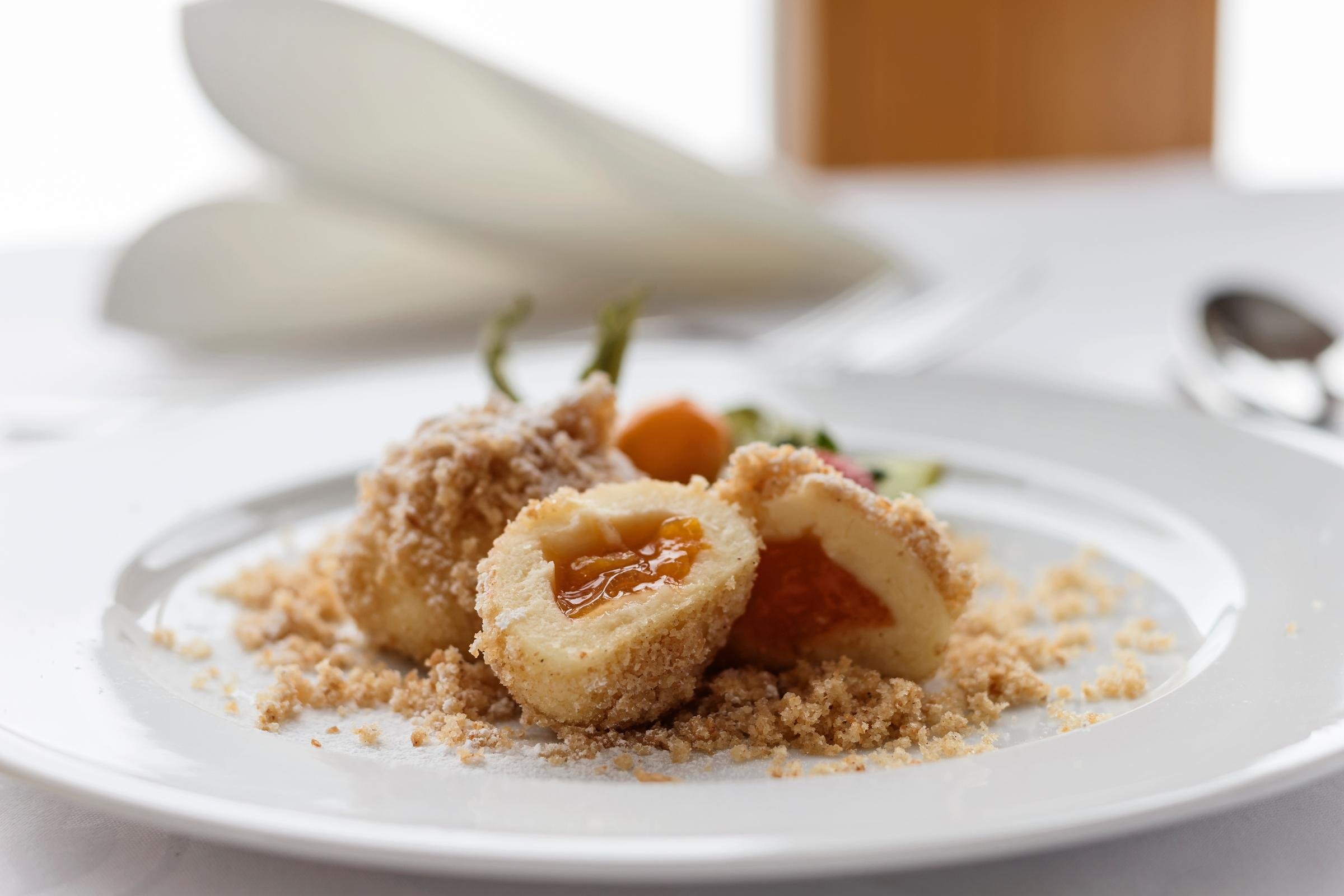 Ein elegantes Dessert mit Keks, Fruchtfüllung und Vanille auf weißem Teller