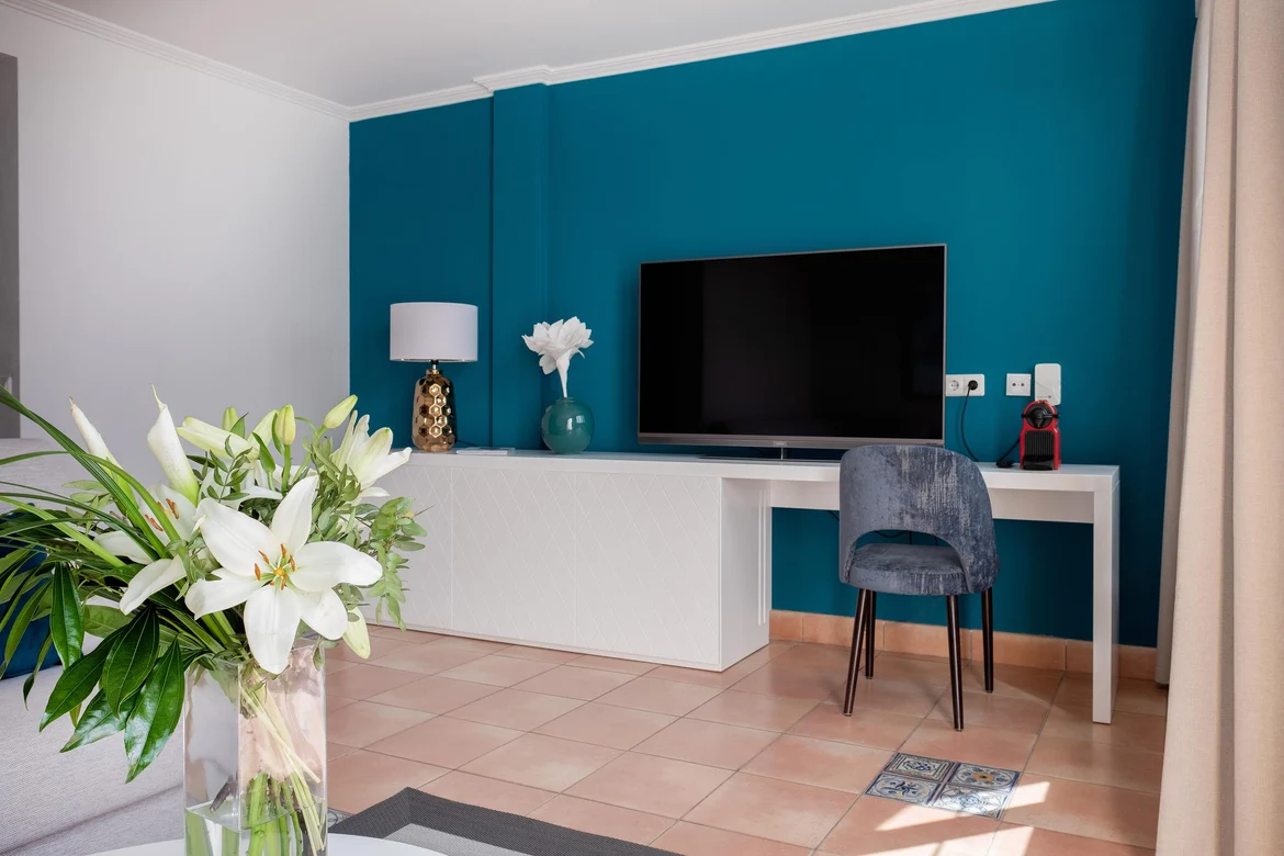 Ein modernes Zimmer mit TV, Lampen und Pflanzen für einen angenehmen Aufenthalt.