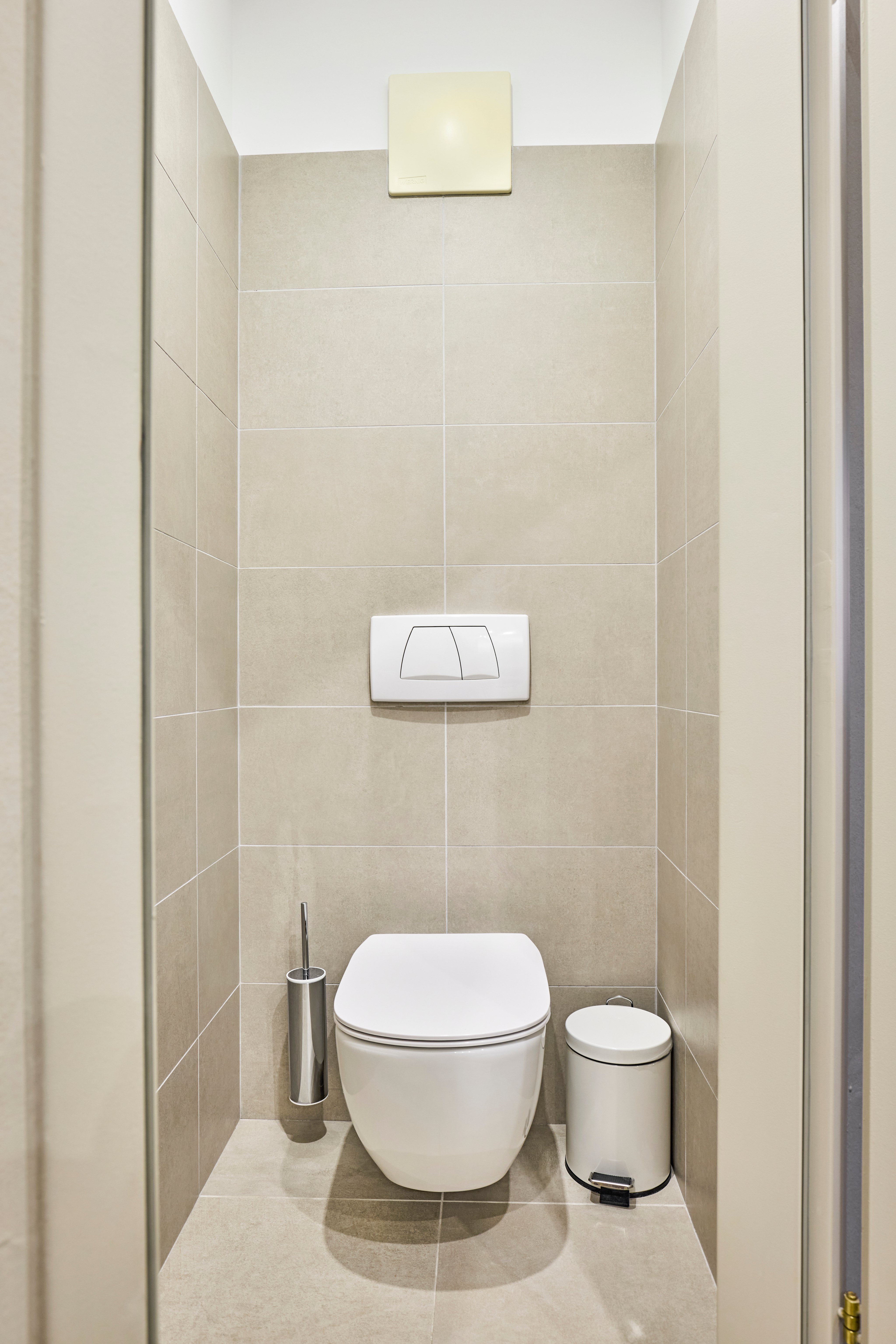 Modern und helle Toilette mit drehbarer WC-Spülung und Mülleimer, elegantes Badezimmerdesign