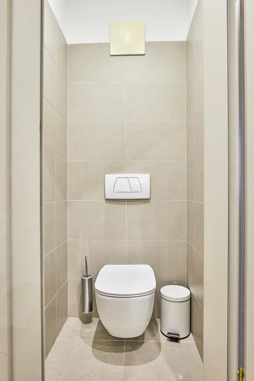 Modern und helle Toilette mit drehbarer WC-Spülung und Mülleimer, elegantes Badezimmerdesign