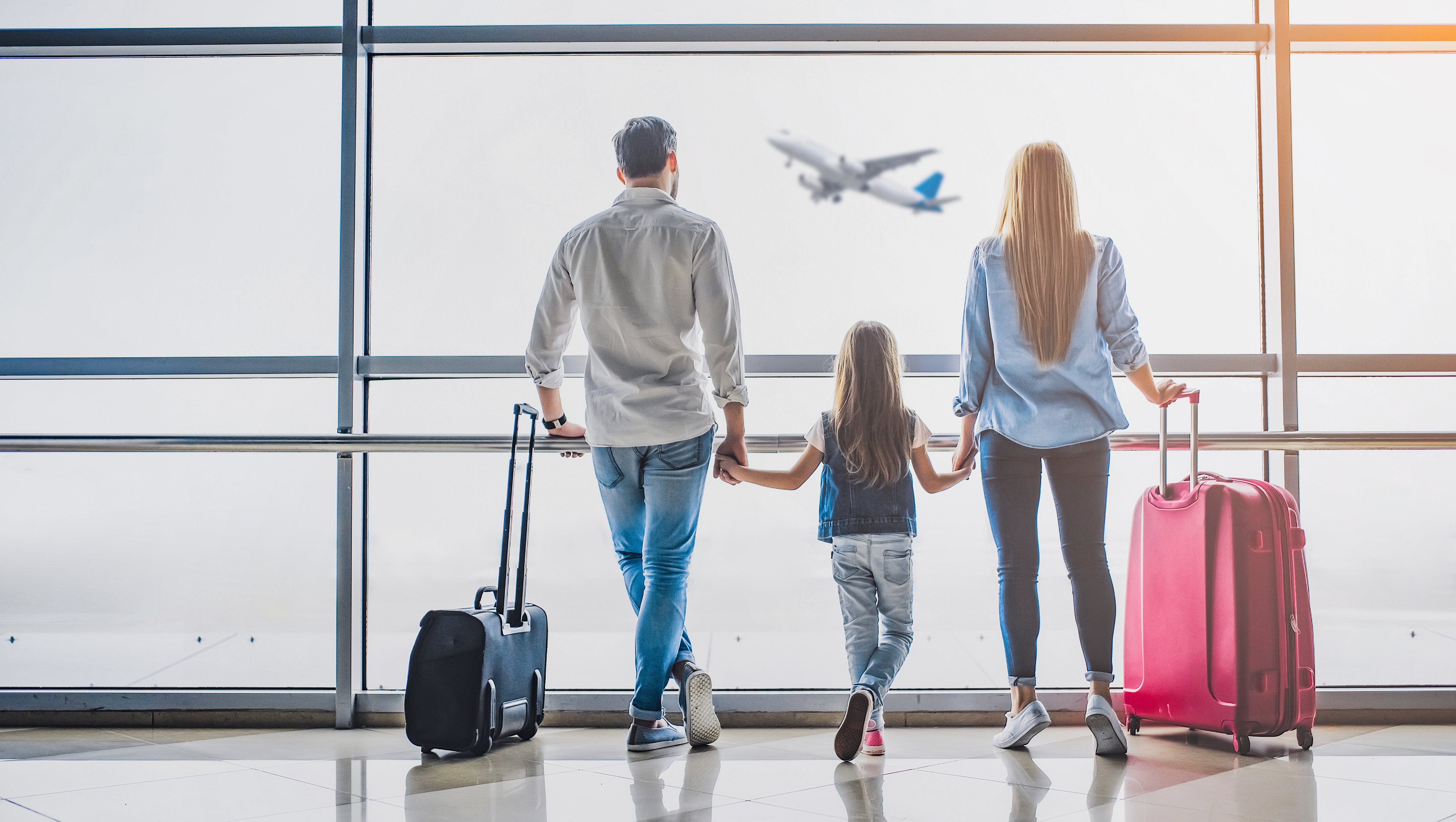 Familie mit Gepäck im Flughafen vor einem Flugzeug, Aldiana Premium Cluburlaub Konzept