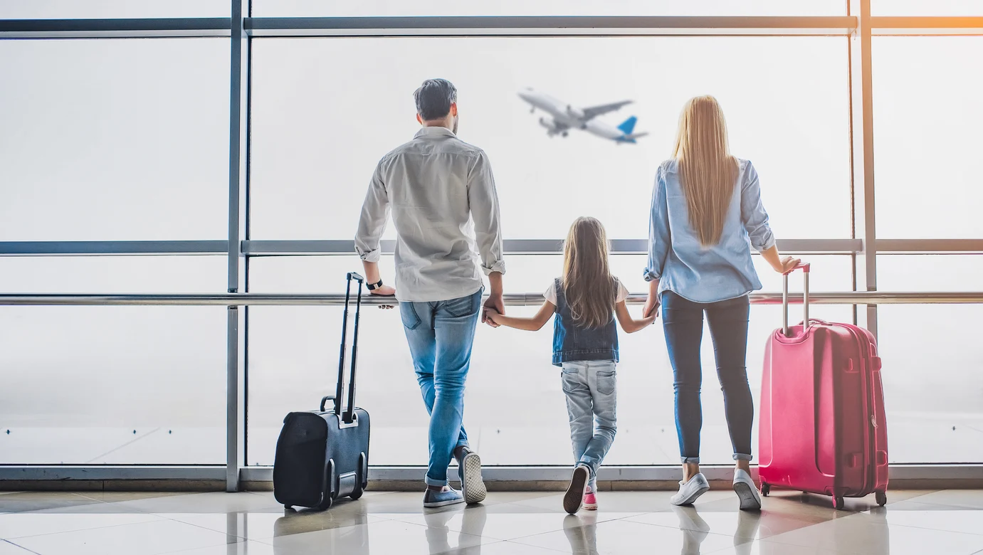 Familie mit Gepäck im Flughafen vor einem Flugzeug, Aldiana Premium Cluburlaub Konzept