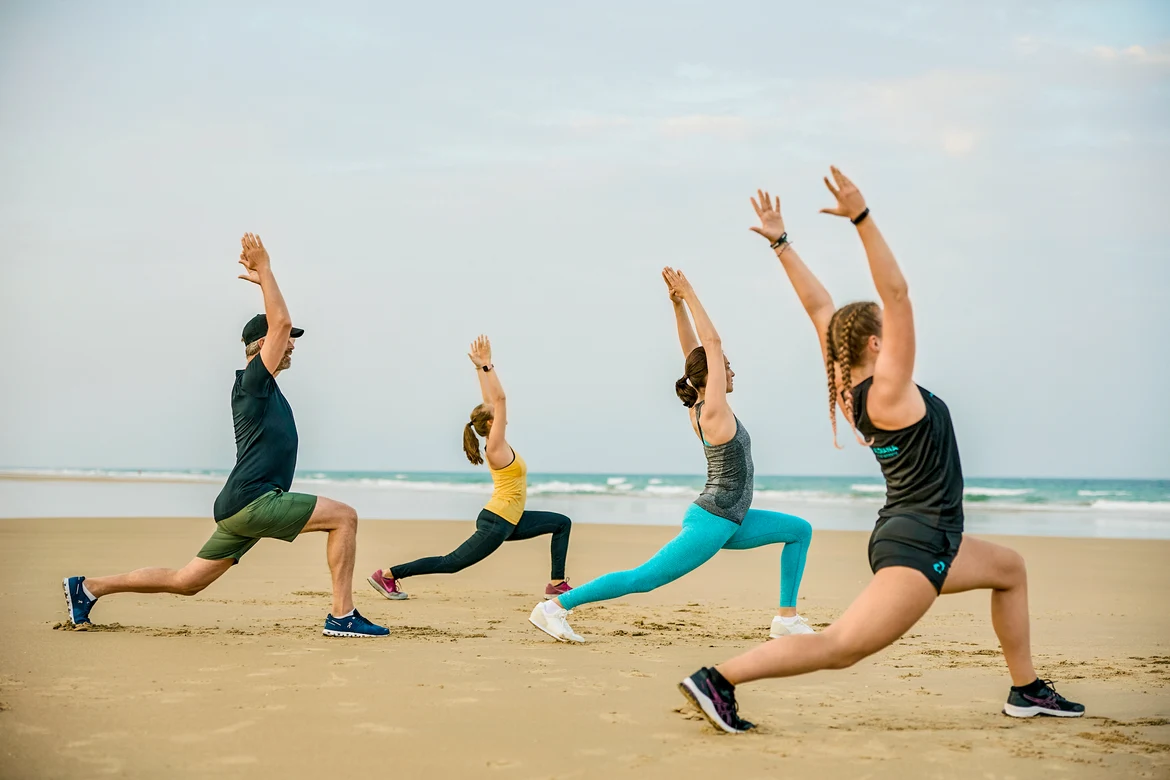 Personen machen Yoga am Strand