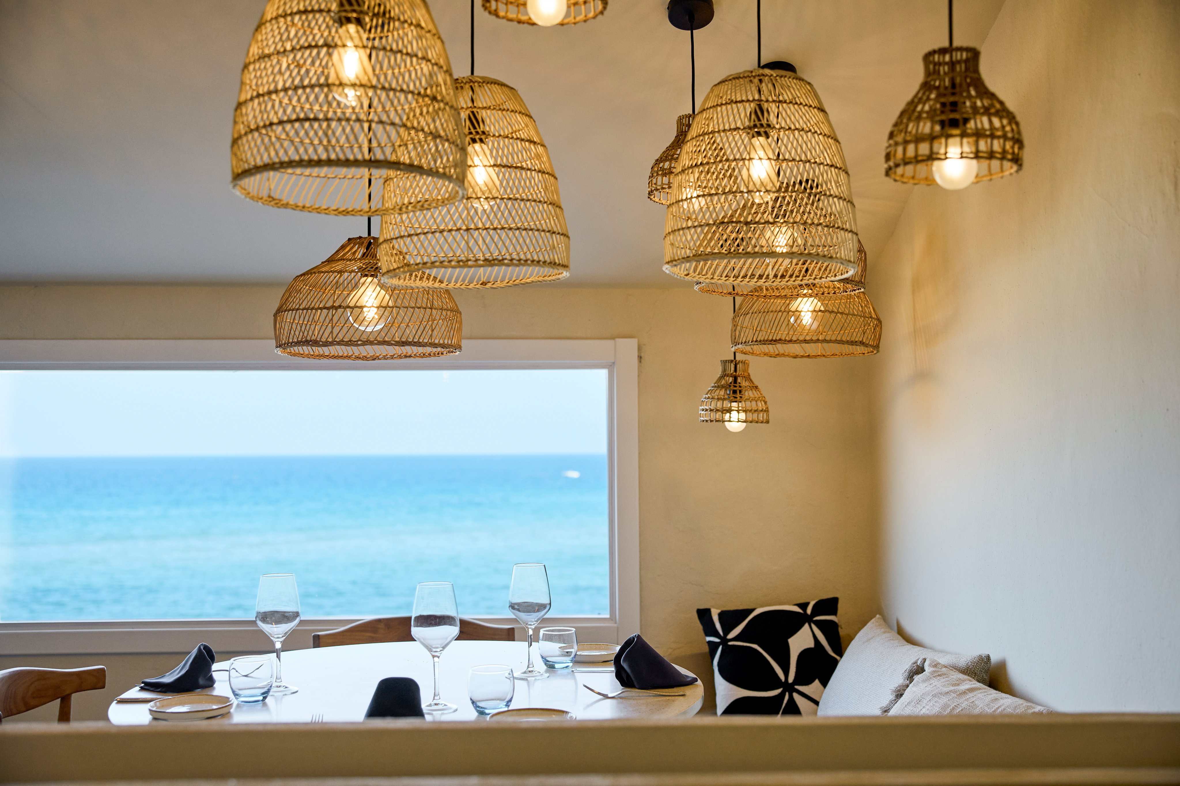 Gemütlicher Essbereich mit Blick aufs Meer und stilvollen Leuchten, ideal für Premium Cluburlaub