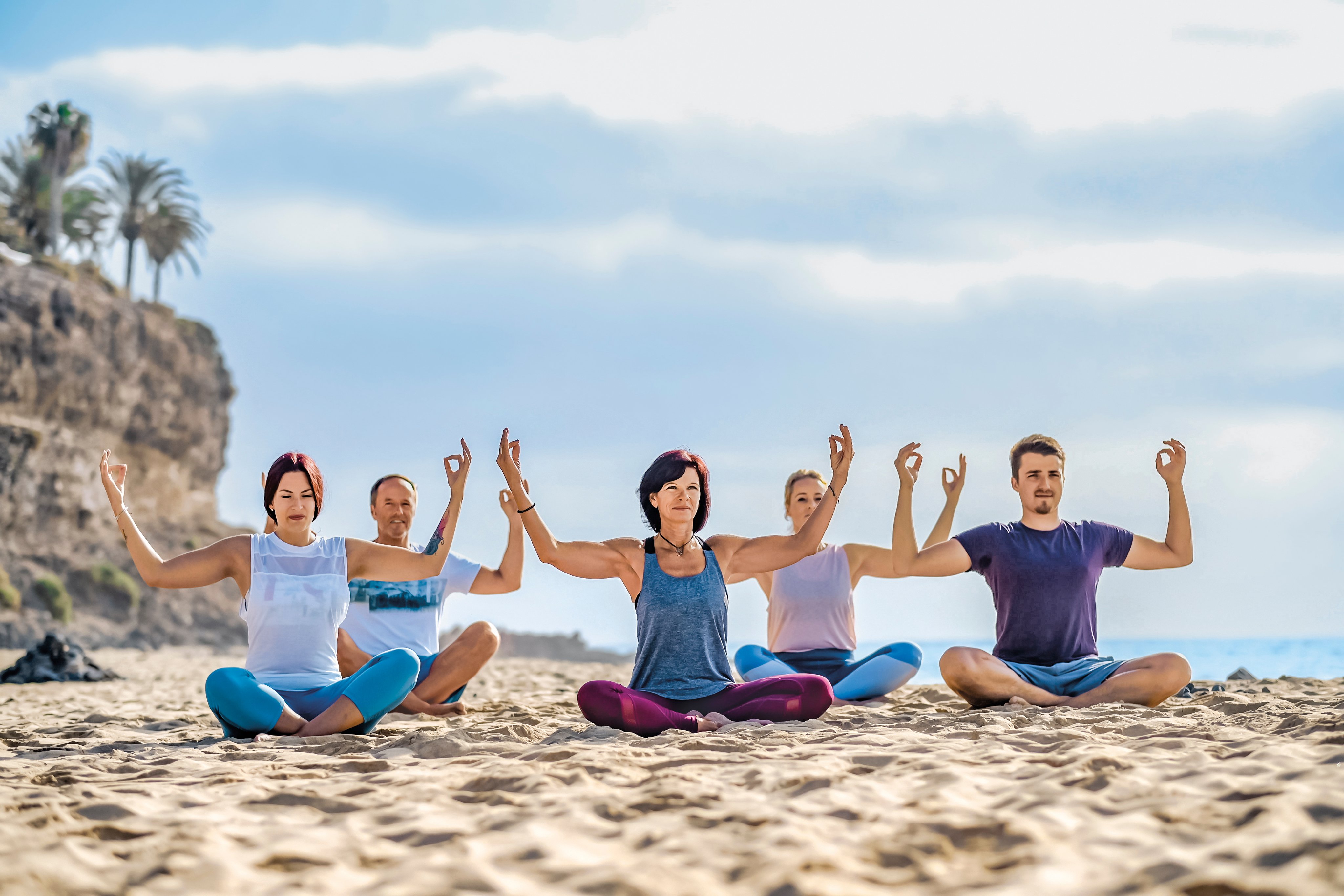Teilnehmer beim Yoga am Strand bei Sonnenuntergang, entspannter Premium Cluburlaub bei Aldiana