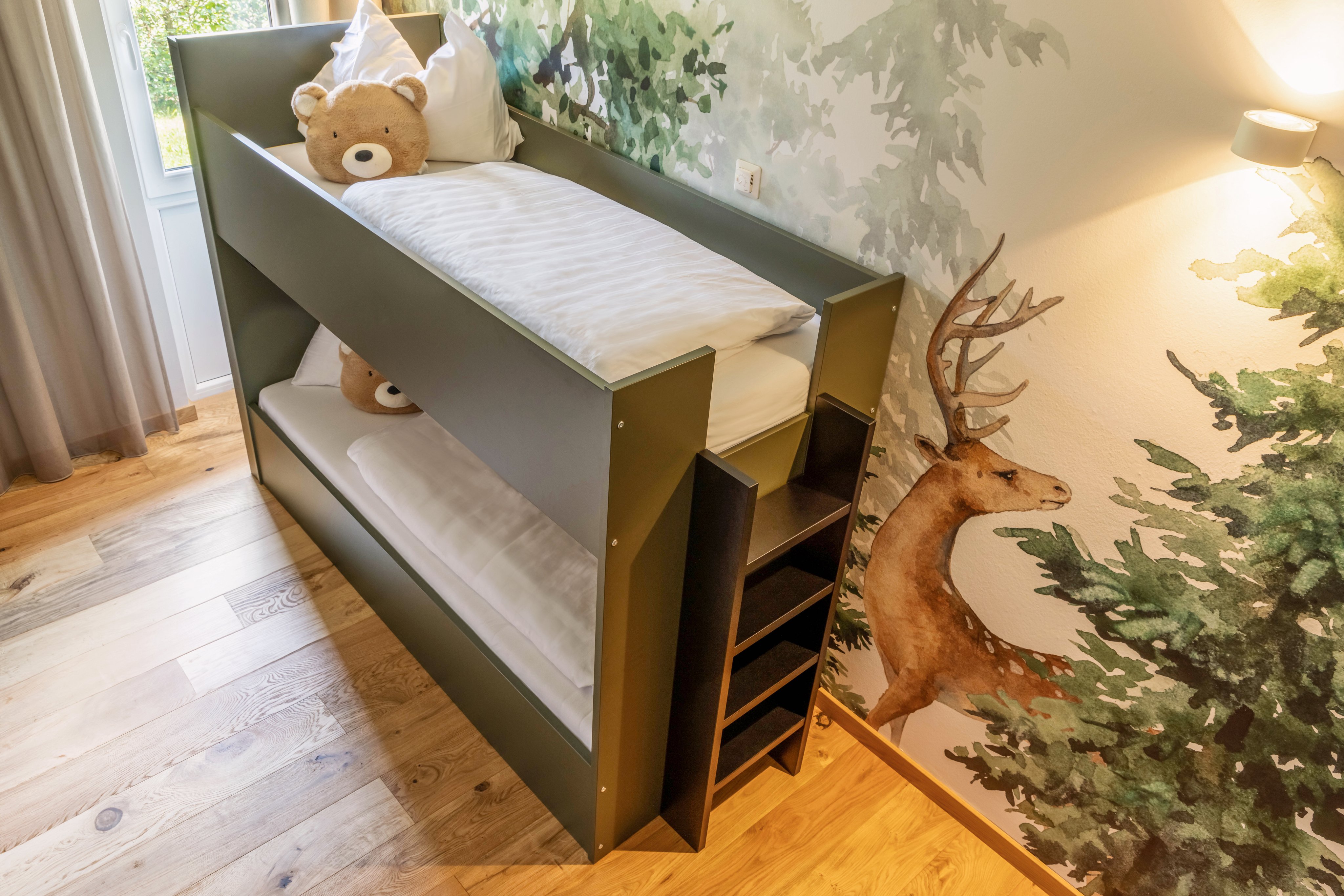 Ein Kinderbett mit Kuscheltier in einem gemütlichen Kinderzimmer bei Aldiana Urlaub