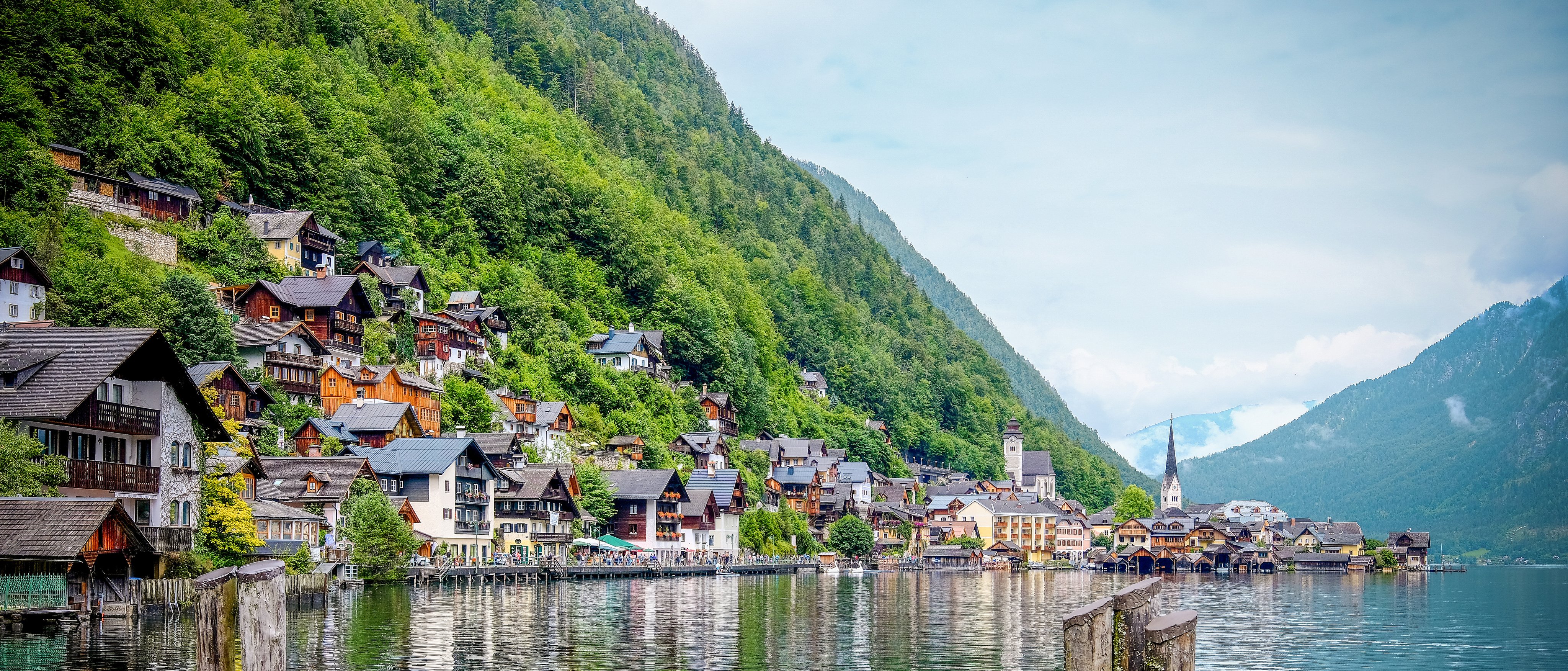 Häuser am Ufer eines Sees vor grünem Berglmaze bei Sonnenaufgang, Urlaubsort bei Aldiana