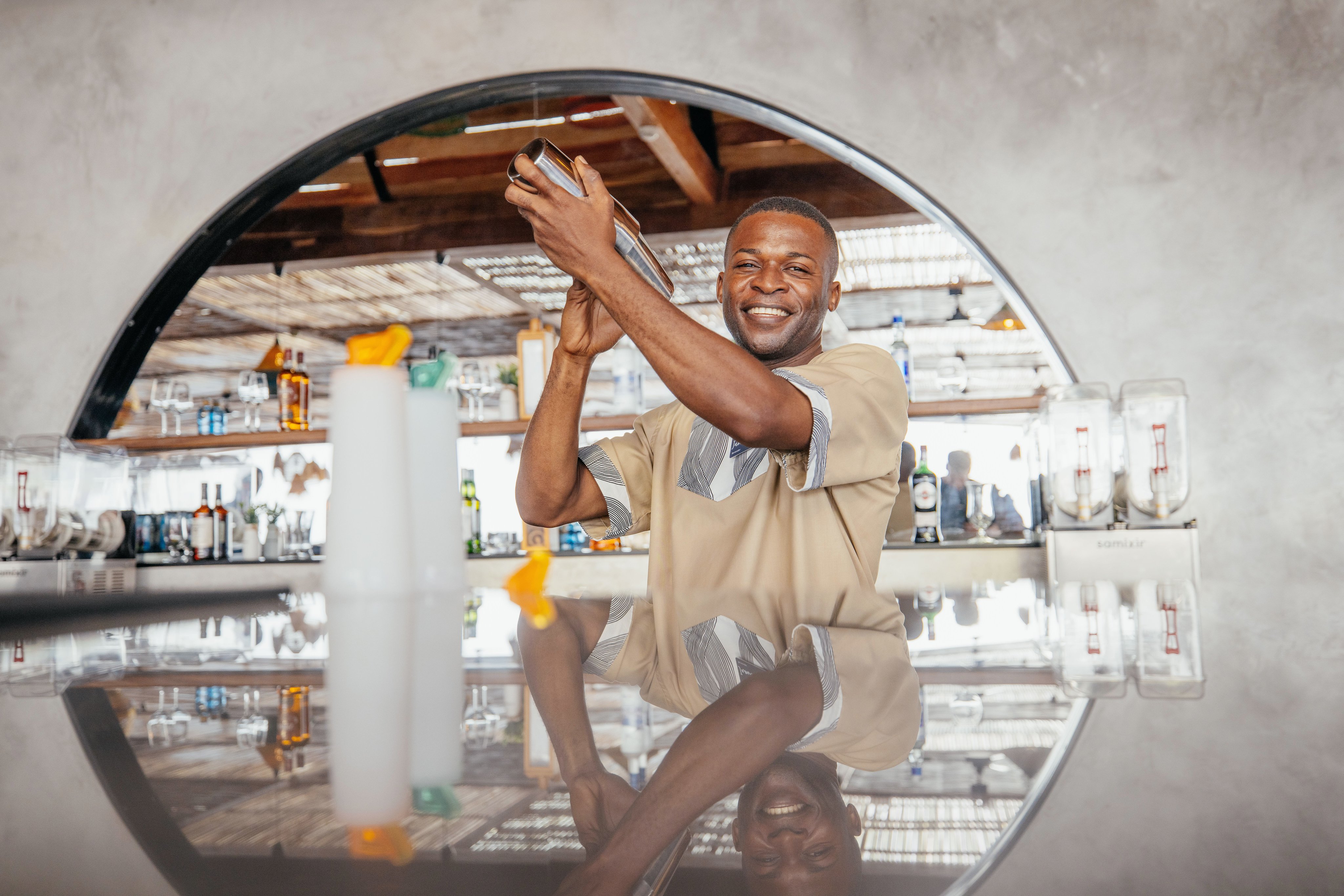 Person sitzt im Restaurant und trinkt, im Hintergrund moderne Einrichtung und Natur.