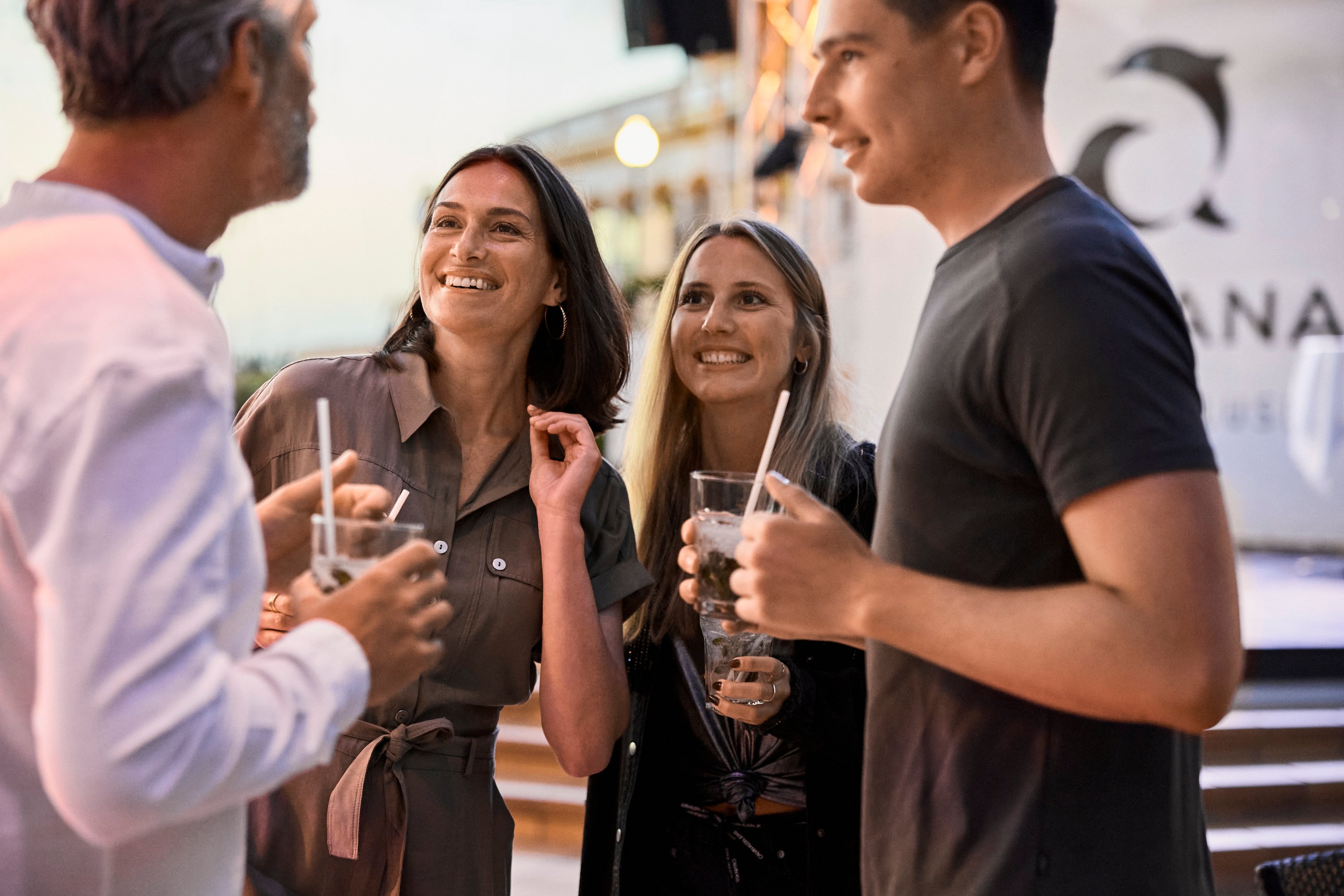 Mehrere Personen bei einem geselligen Gespräch mit Getränken im Outdoor-Bereich bei Aldiana hochwertiger Cluburlaub