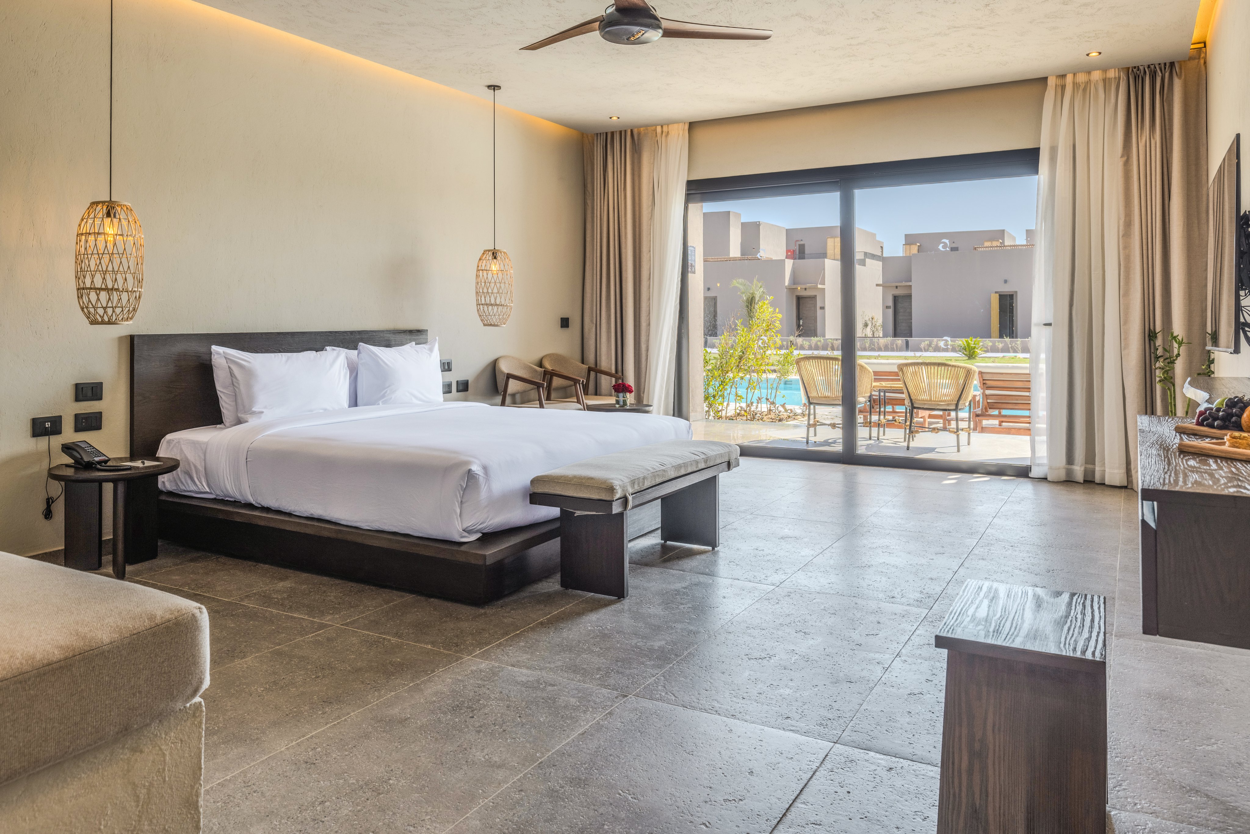 Moderne Hotelzimmer bei Aldiana mit gemütlichem Bett und Blick auf den Balkon.