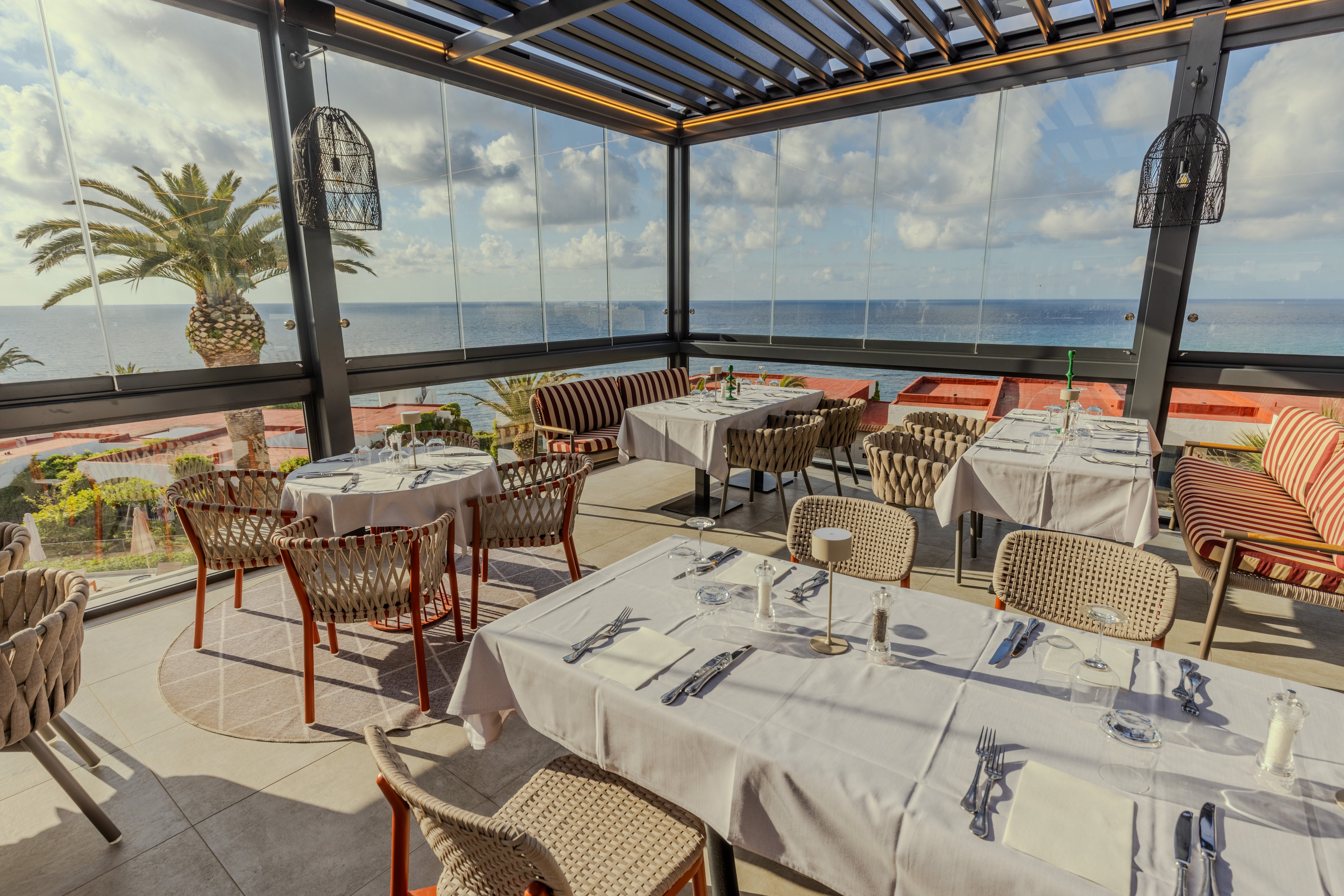 Helles Restaurant mit Blick auf das Meer, gedeckte Tische im Premium Cluburlaub.