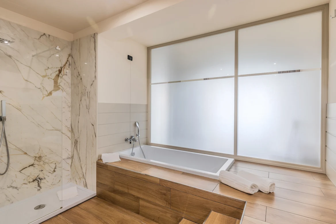 Luxuriöses Badezimmer mit Badewanne, Holzdesign, frosted Fenster und hellem Ambiente