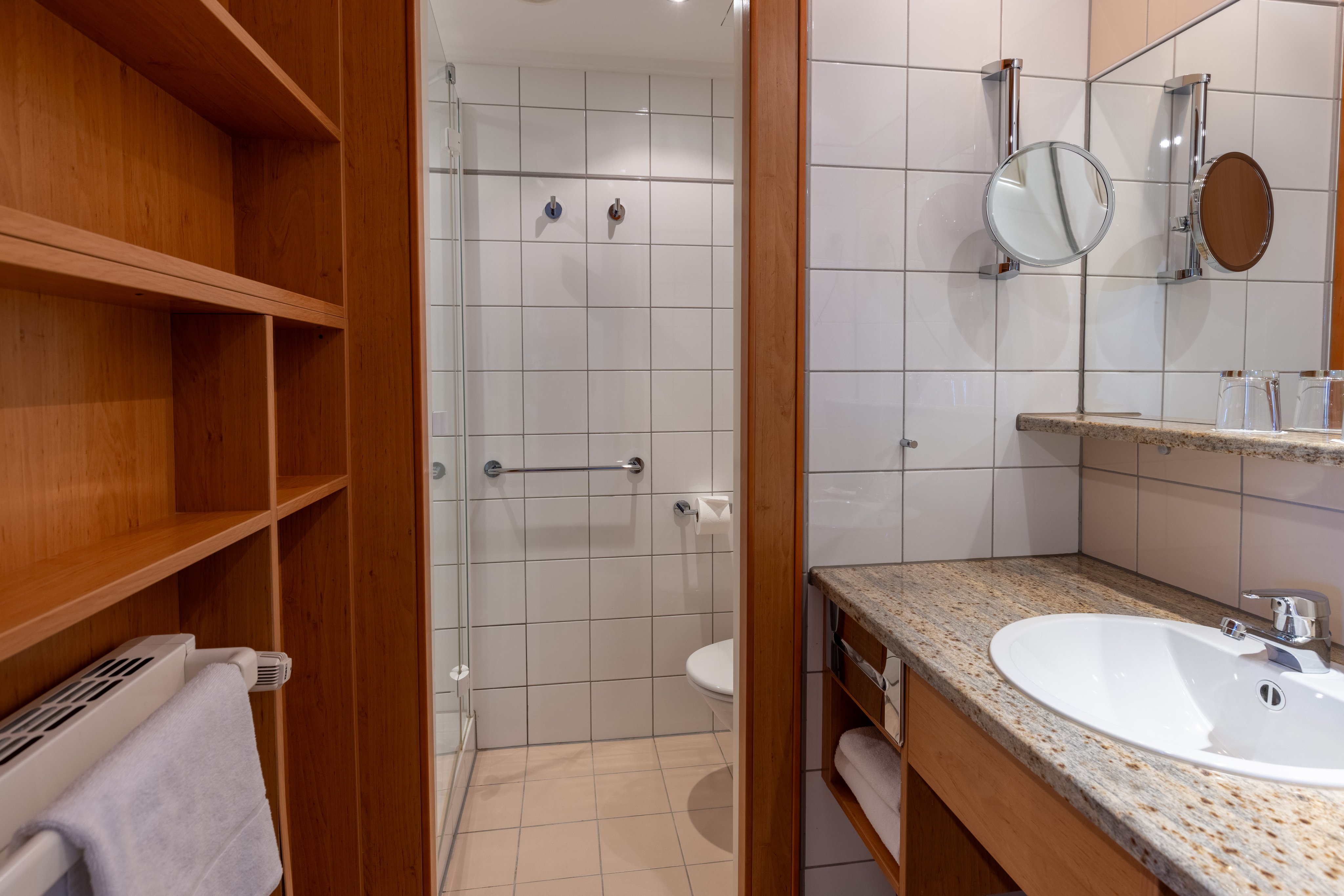 Badezimmer im Aldiana Club mit Waschbecken Spiegel und Dusche, hochwertig eingerichtet