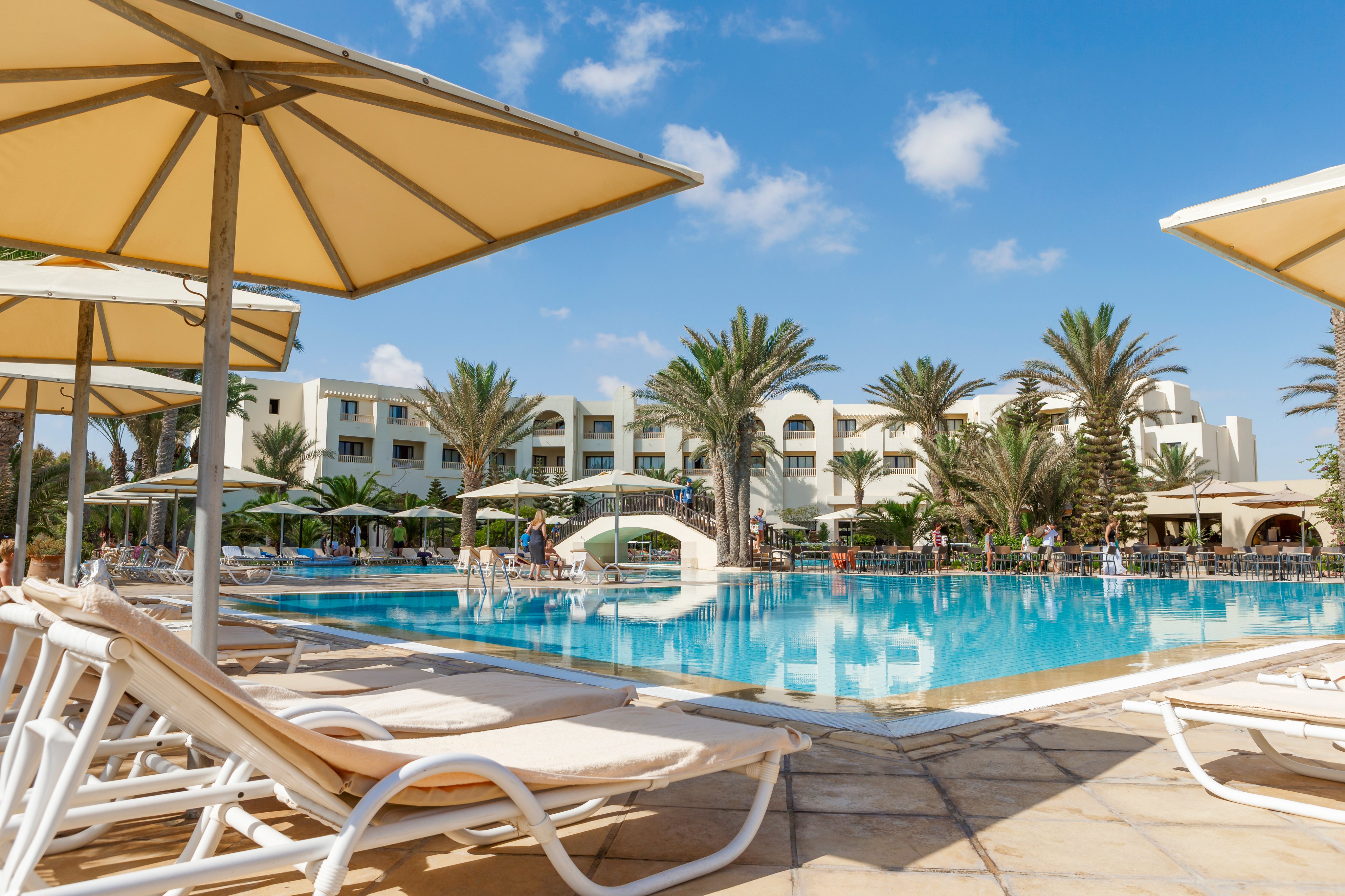 Luxuriöses Poolgebiet im Aldiana Premium Cluburlaub mit Sonnenschirmen und Palmen