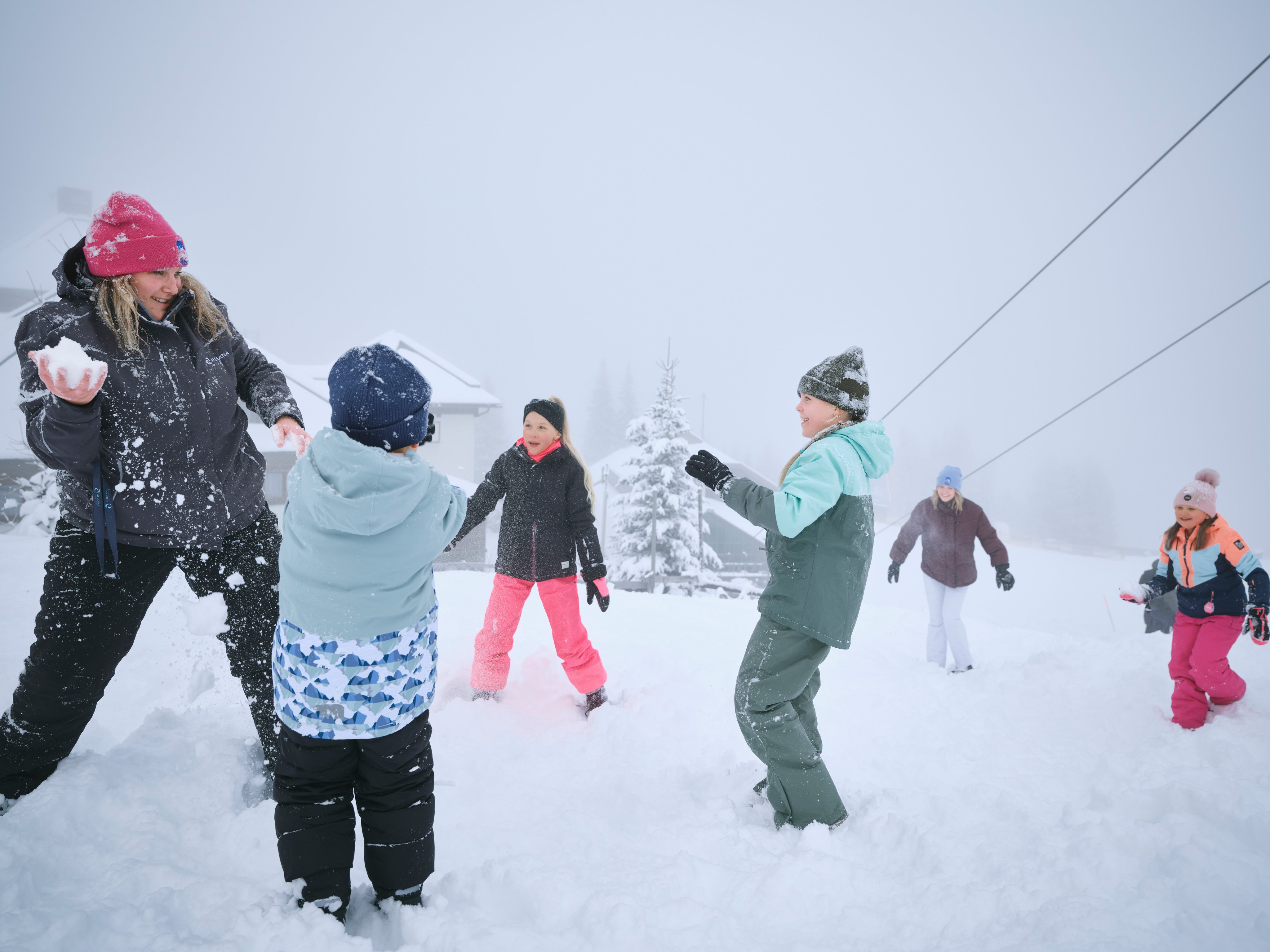 Familien beim Schneespiel in verschneiter Landschaft bei Aldiana Premium Cluburlaub