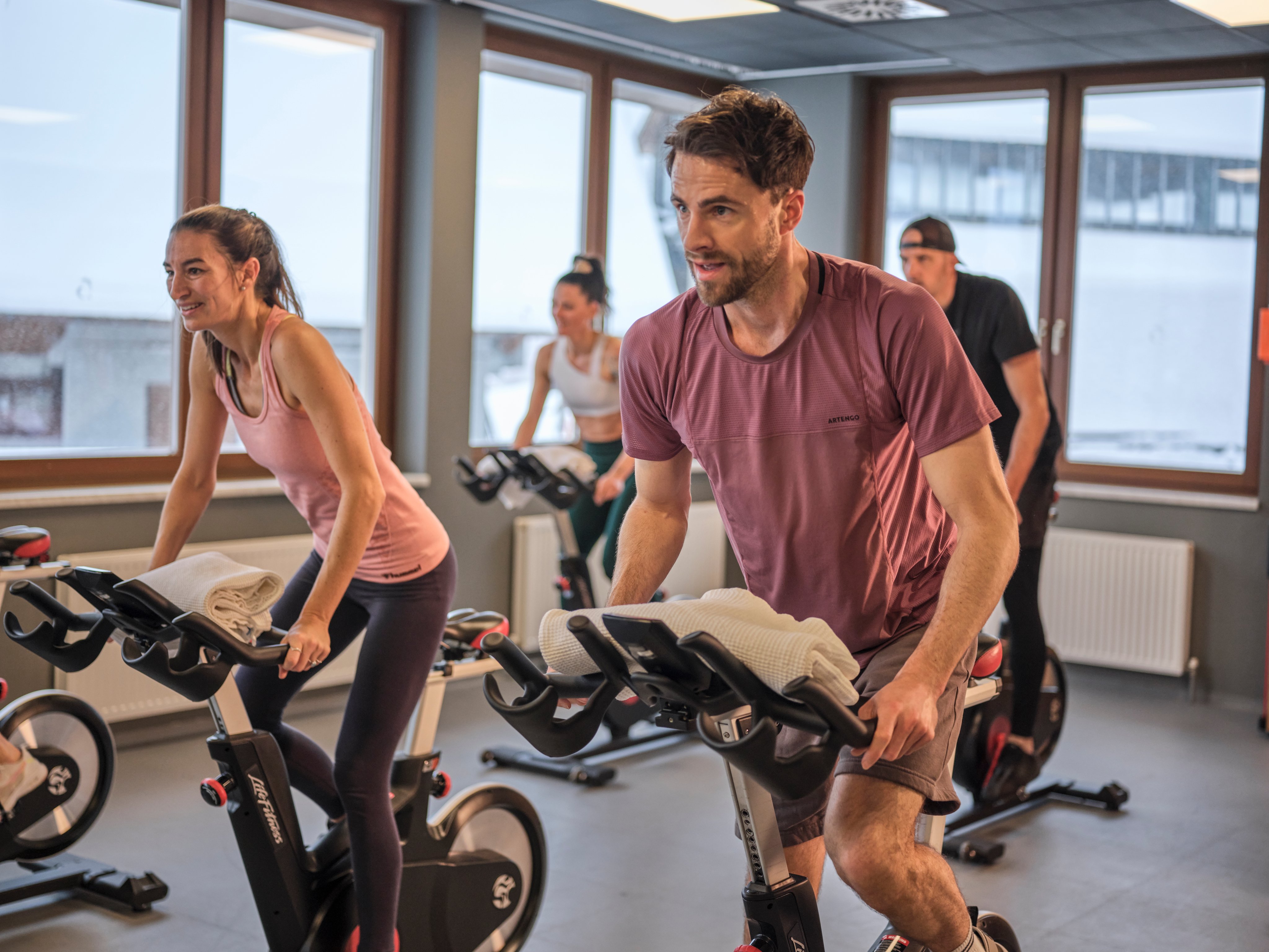 Menschen beim Indoor-Training in einem modernen Fitnessstudio, nachhaltiges und premium Cluburlaub-Angebot